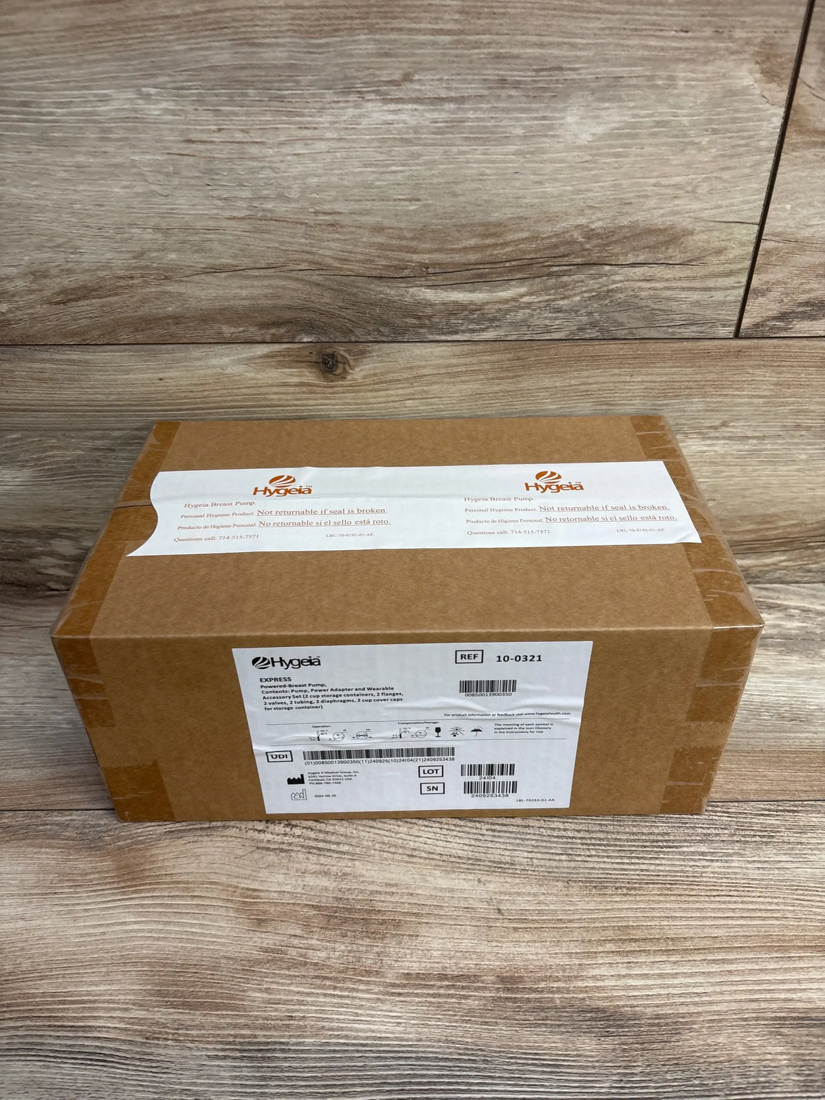 Sealed cardboard box labeled Hygeia Express Breast Pump on wood surface with shipping and product details