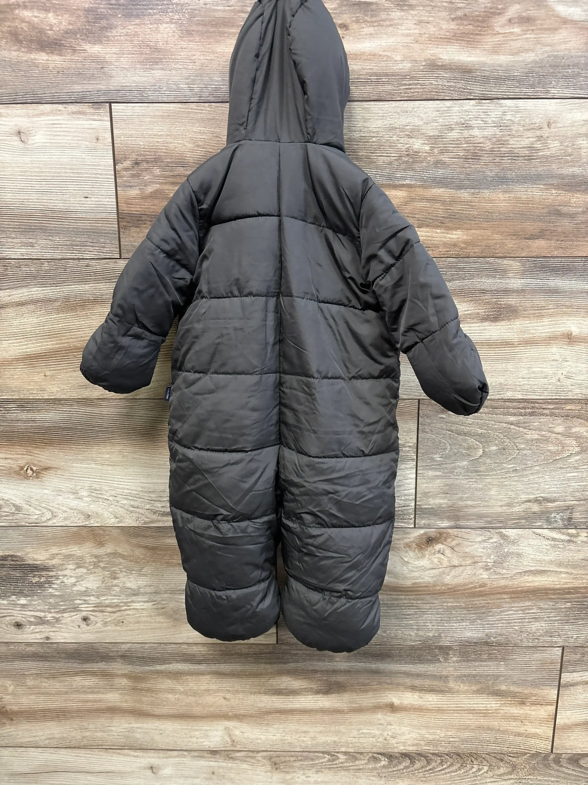 Back view of Baby Gap ColdControl Max snowsuit showing quilted insulation and attached hood on wood-plank background