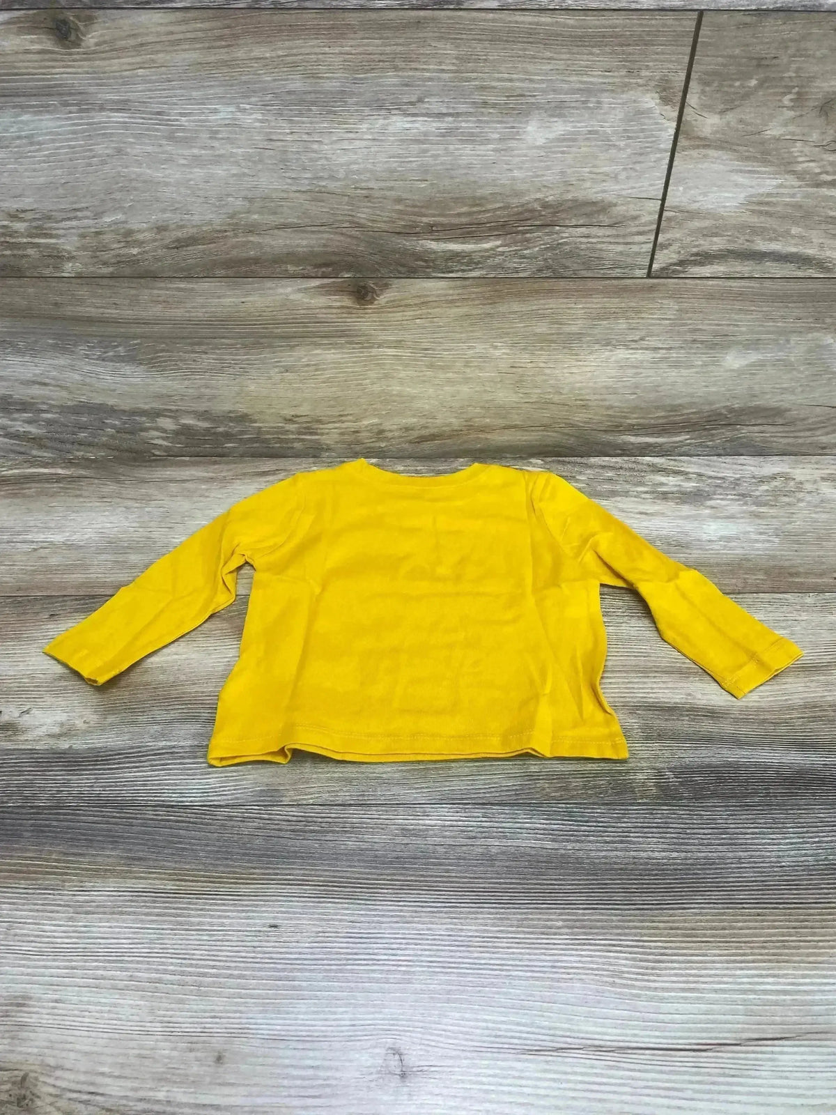 Back view of Old Navy yellow long-sleeve toddler shirt showing crew neck on wood floor background, size 12-18 months