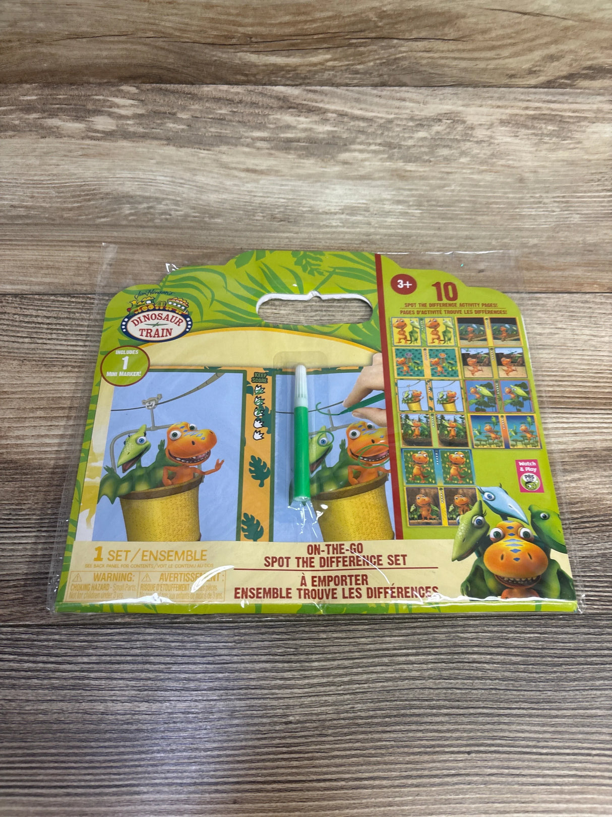Dinosaur Train spot the difference activity set for kids with green marker on wood background