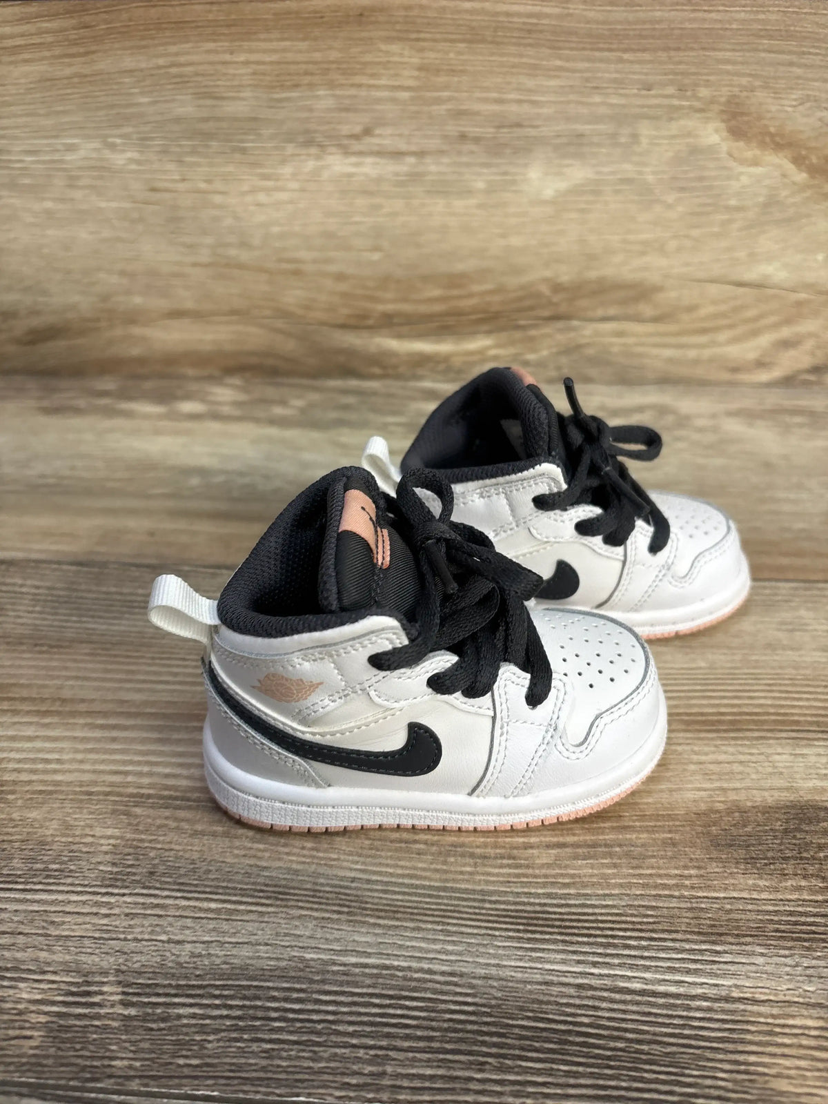 Air Jordan 1 Mid TD White Arctic Orange toddler sneakers on a wood background