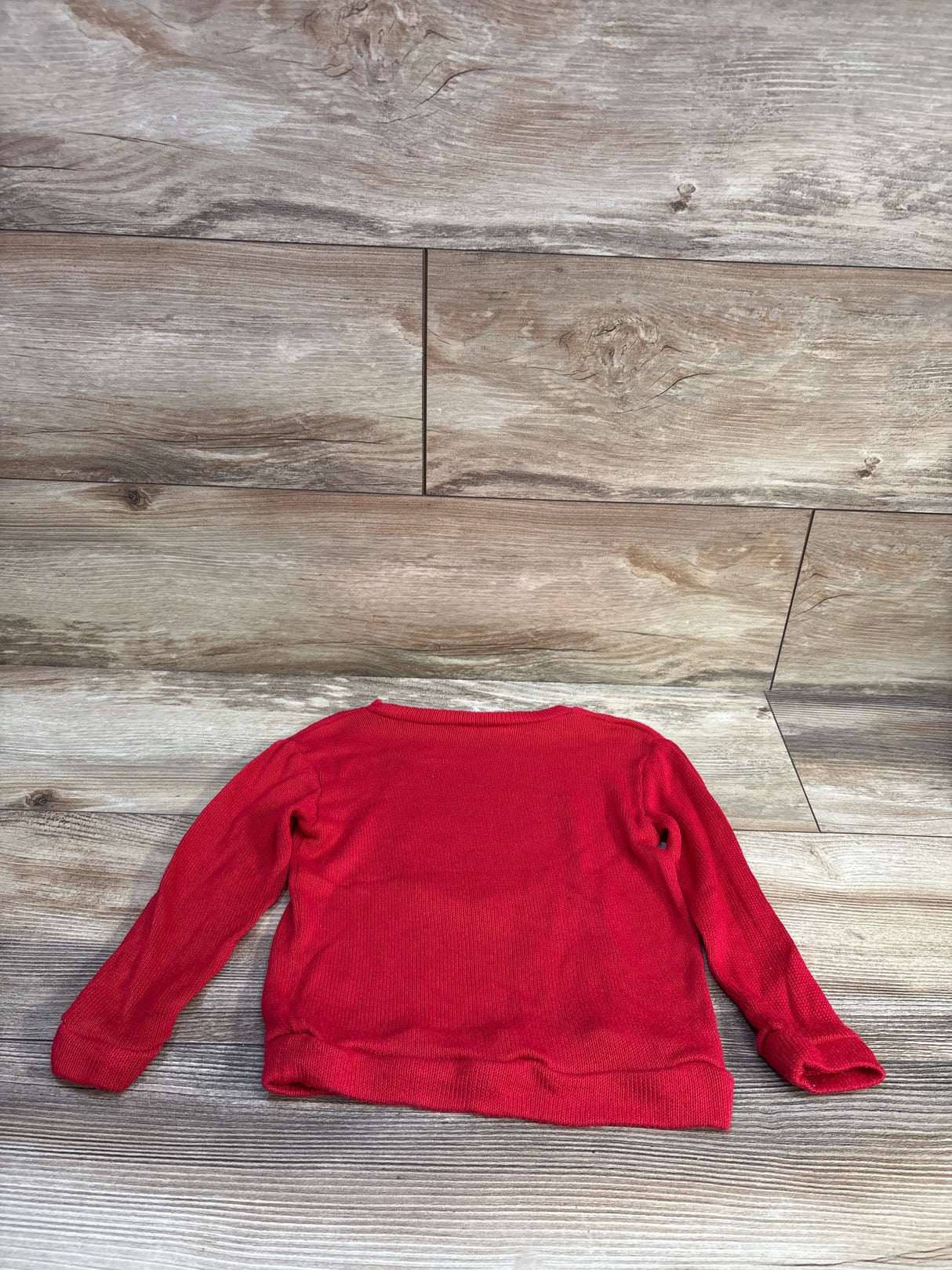 Back view of red Disney Minnie Mouse knit toddler sweatshirt size 2T showing knit texture and long sleeves on wood floor background