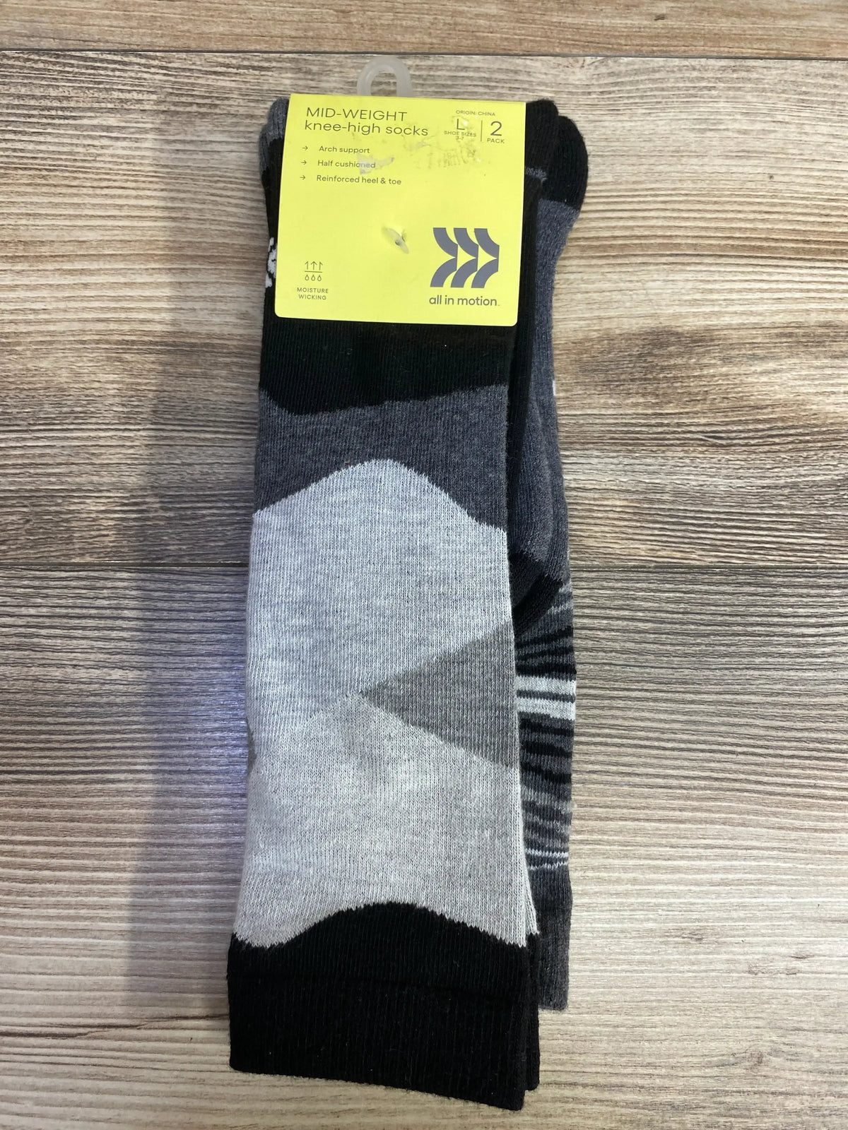 Pack of two mid-weight knee-high socks with geometric gray and black patterns on wooden surface
