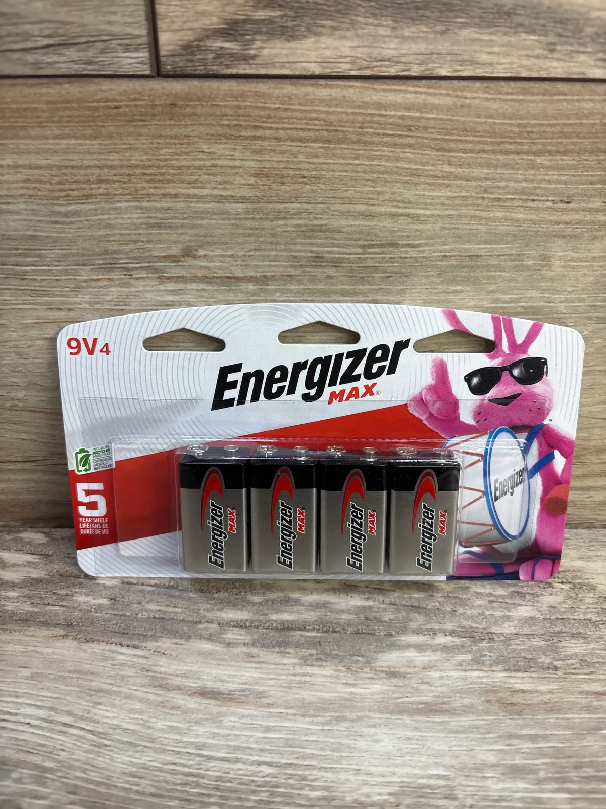 Front view of 4-pack Energizer Max 9V alkaline batteries in blister pack showing battery terminals and bunny on wood surface
