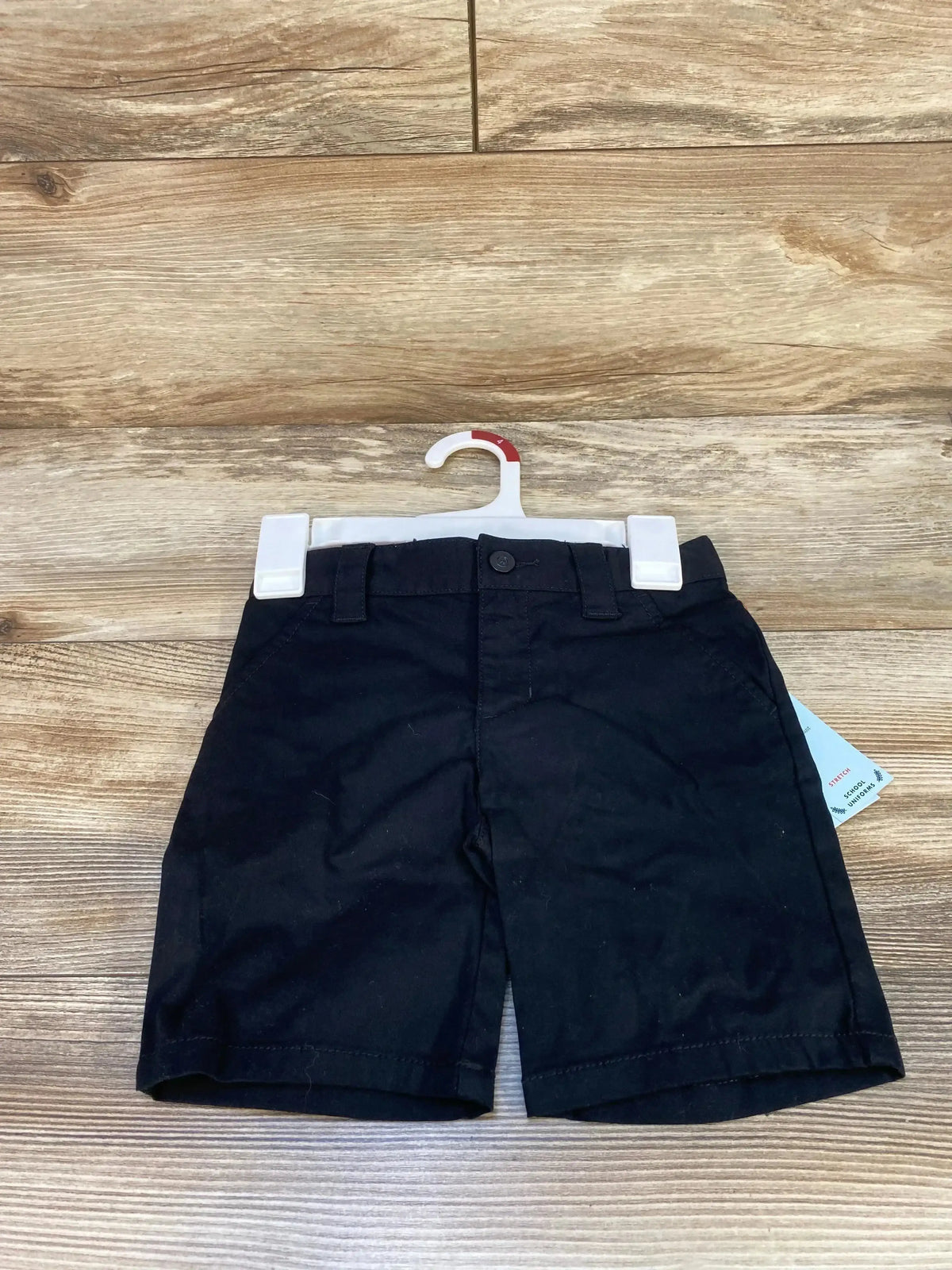 Front of Cat and Jack black toddler school uniform shorts size 4T showing button waist and belt loops on wood