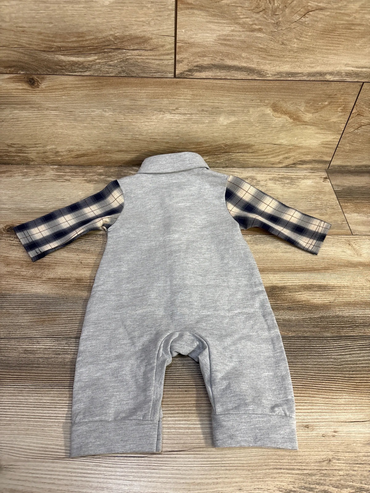 Back view of HOSUKKO gray vest romper showcasing plaid sleeves on a wood-look floor