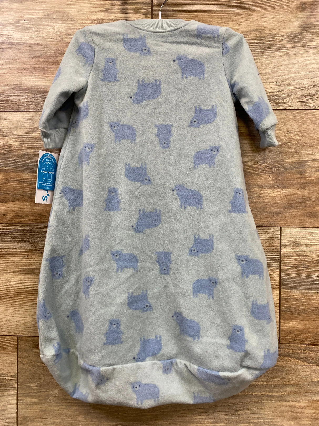 Front view of NEW Carter’s blanket sleep sack in grey with blue bear print and original hangtag on hanger on wood plank floor