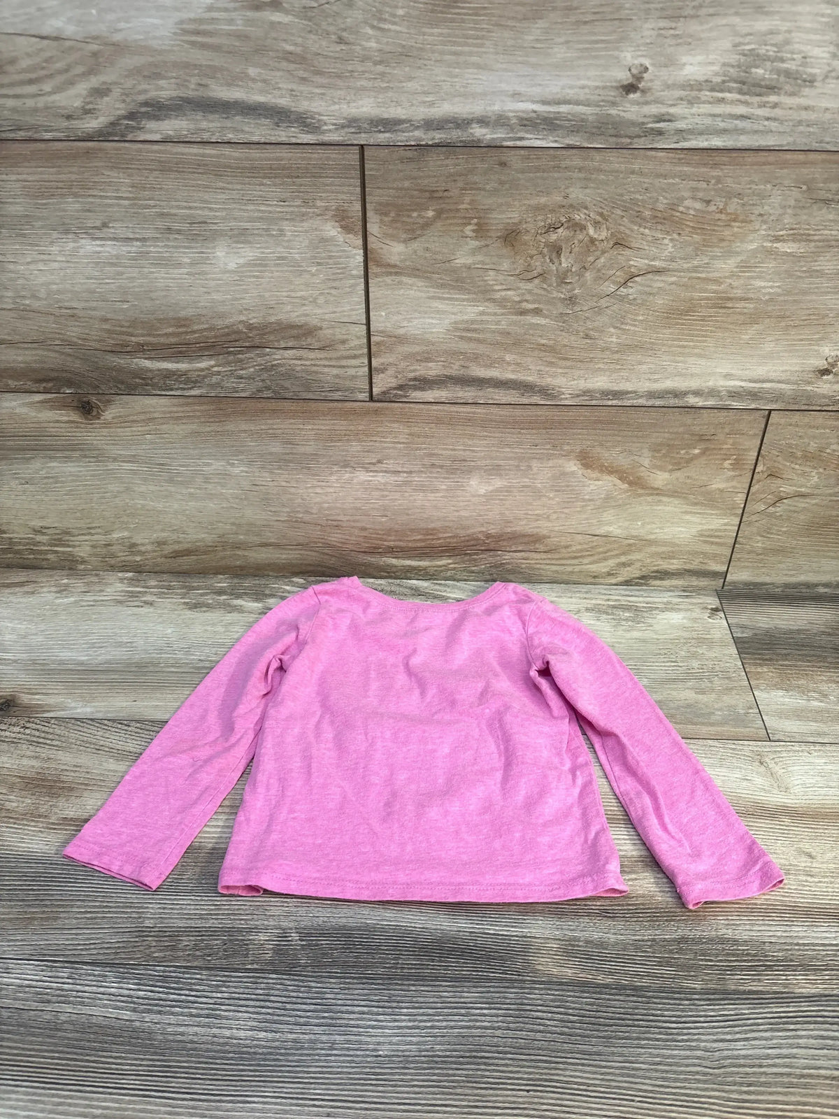 Back view of Children’s Place pink long-sleeve toddler shirt showcasing heathered knit fabric and crew neckline on wood plank floor