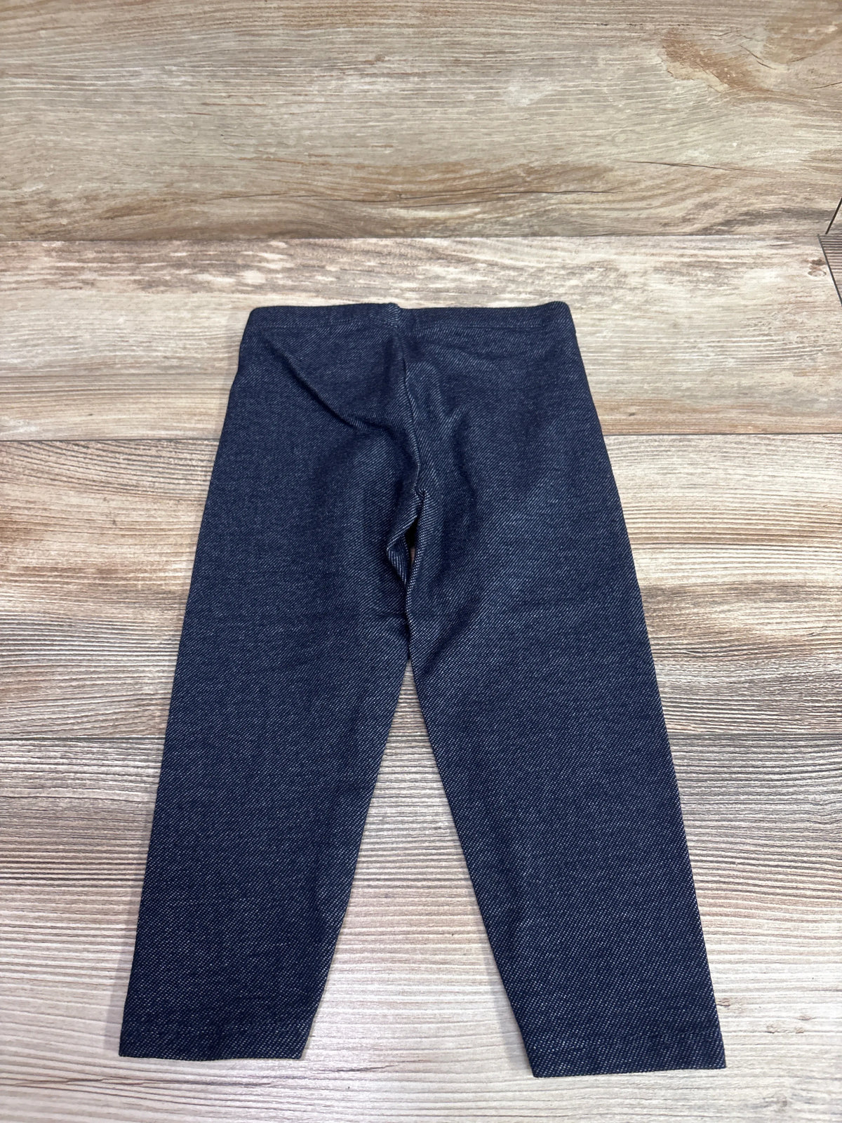 Navy blue Cat & Jack leggings for toddlers size 2T on a light wood background