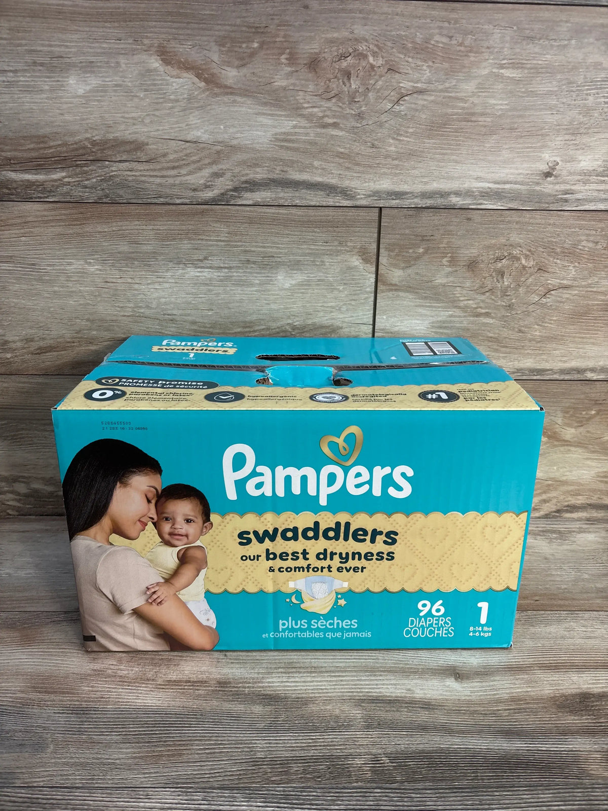 Front view of NEW Pampers Swaddlers diapers Size 1 96 count box showcasing best dryness and comfort on a wood floor