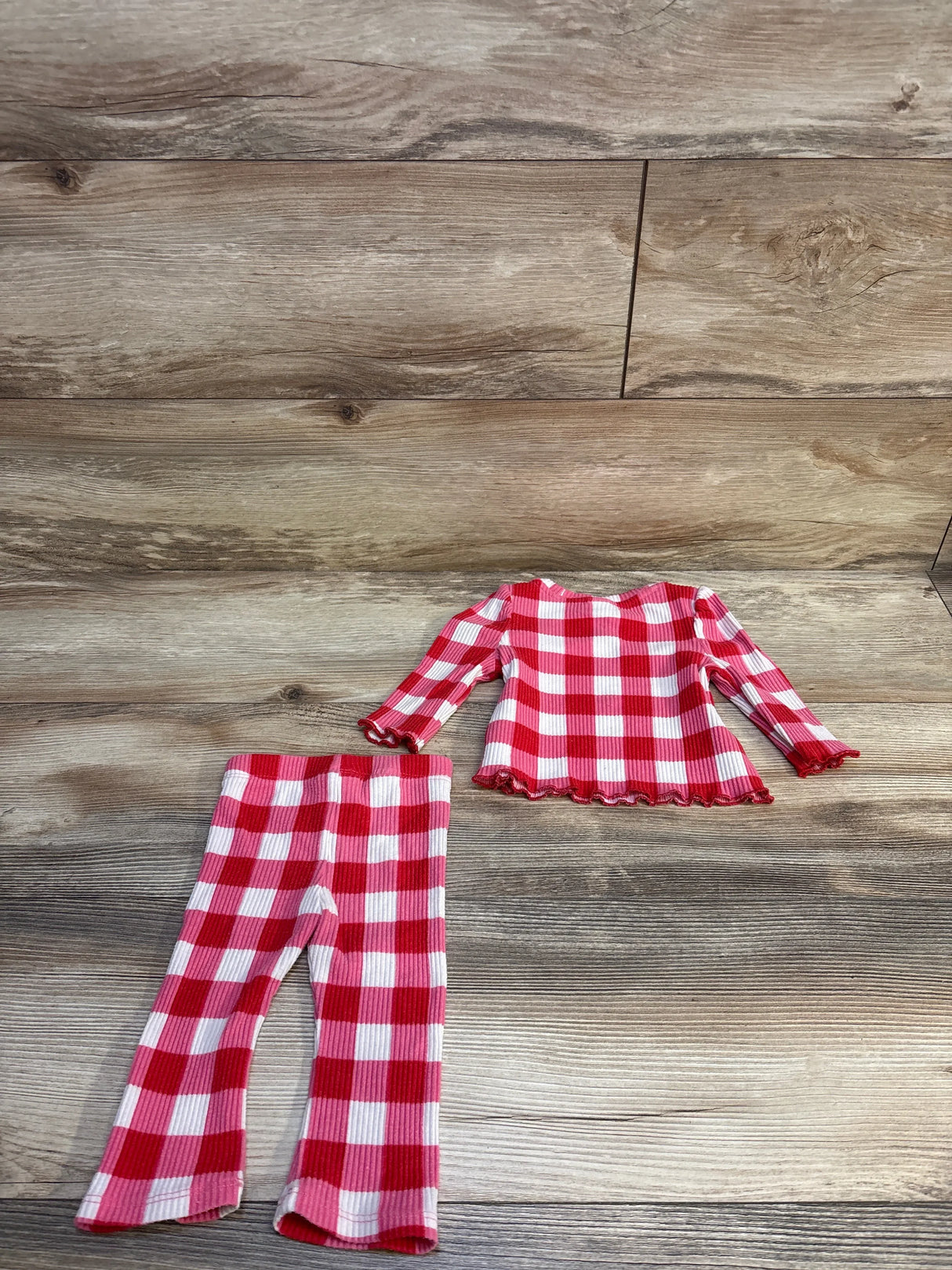 Red and white checkered toddler leggings and long sleeve top set on wood background