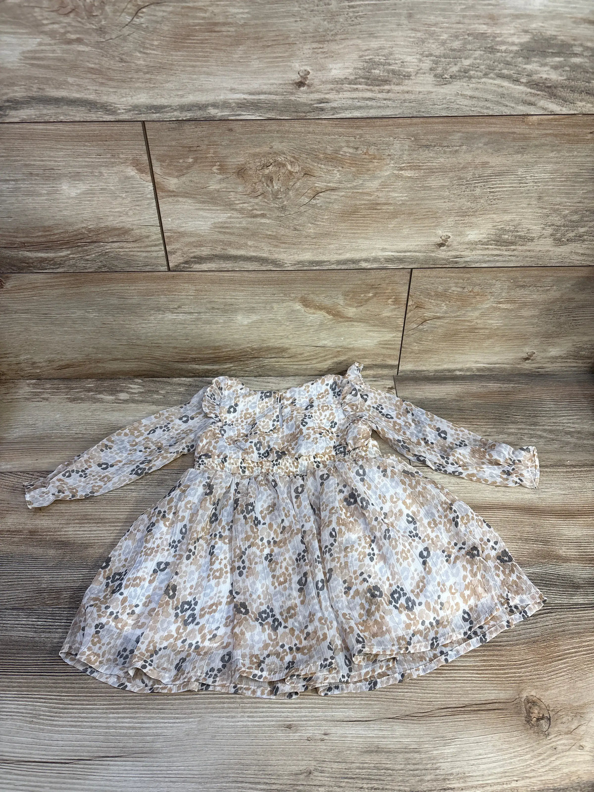 Front view of Nannette beige tulle toddler dress showcasing long sleeves and gathered skirt on a wood floor