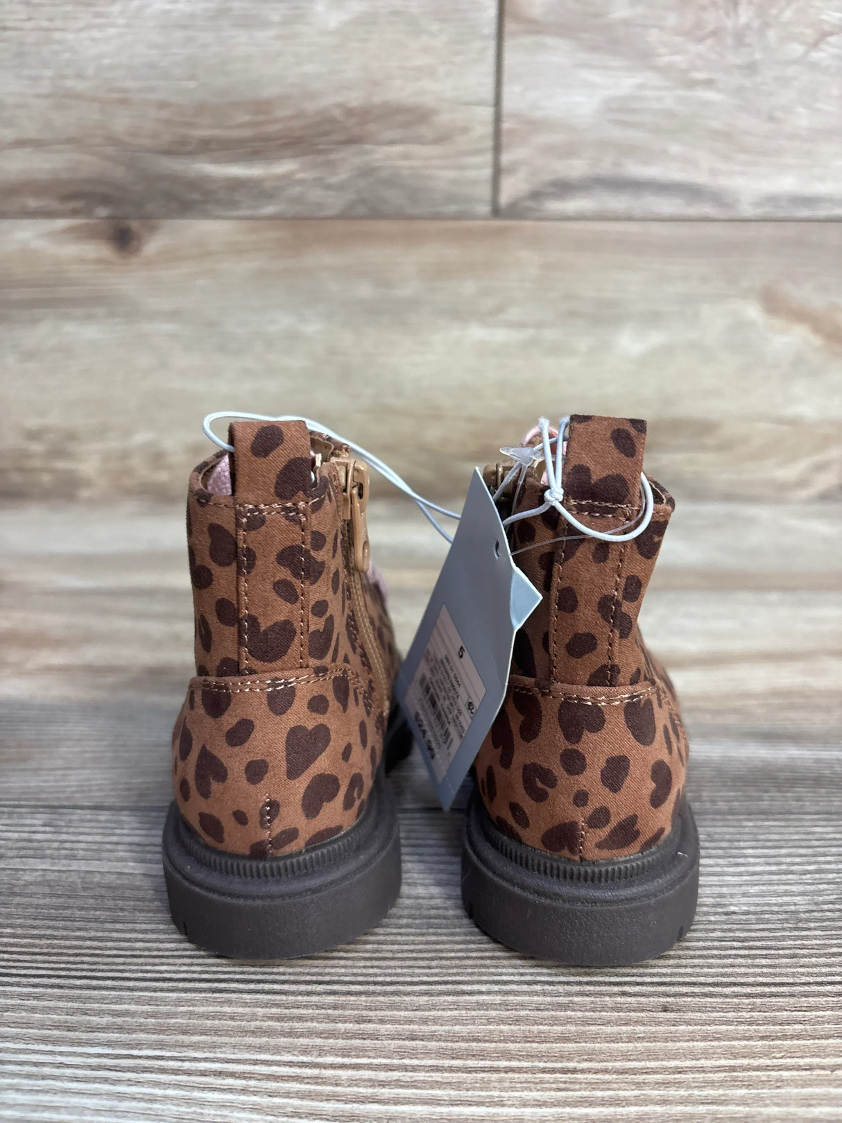 Back view of brown leopard print ankle boots on wooden floor