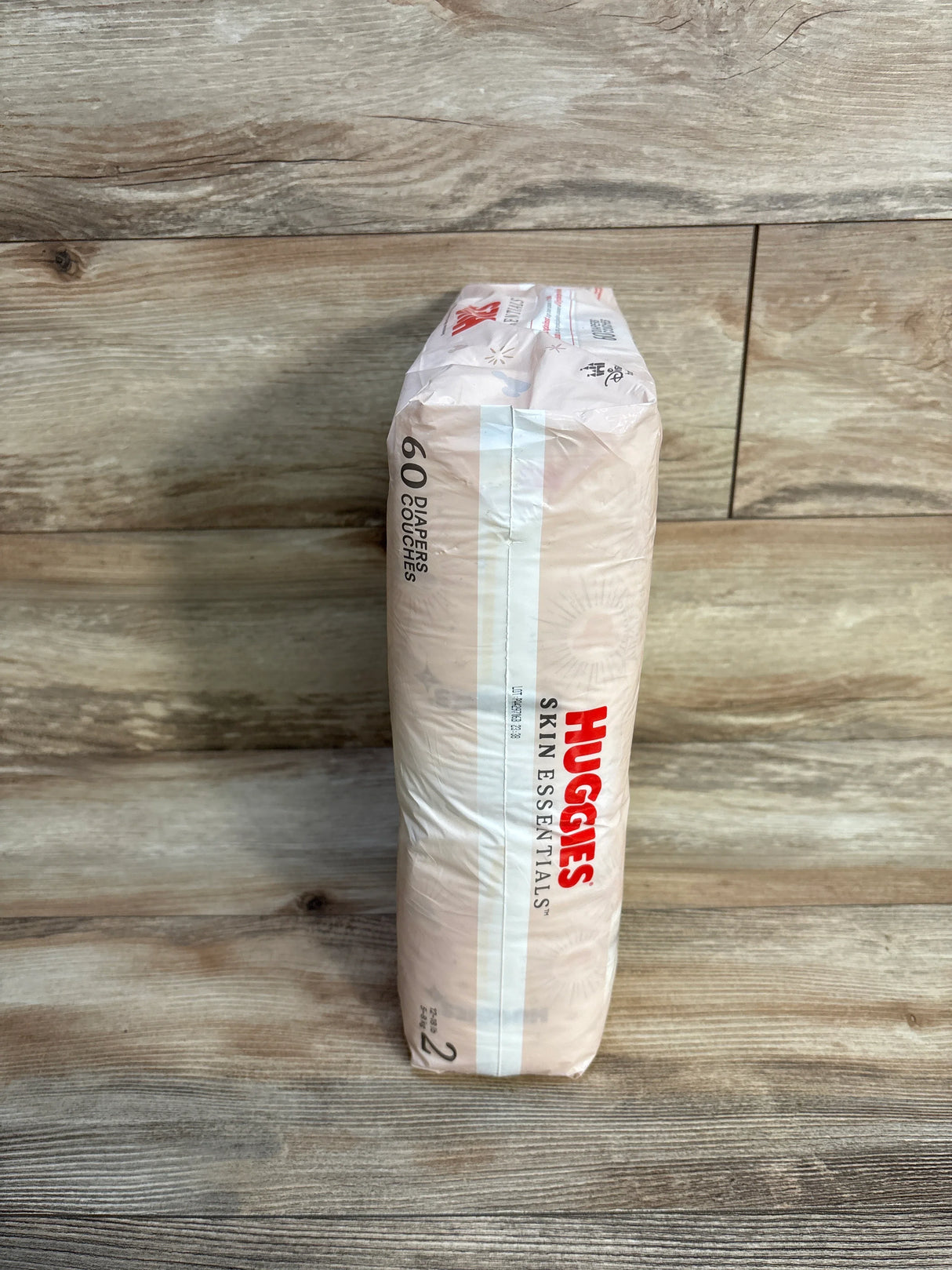 Huggies Skin Essentials size 2 diapers pack of 60 on wood floor