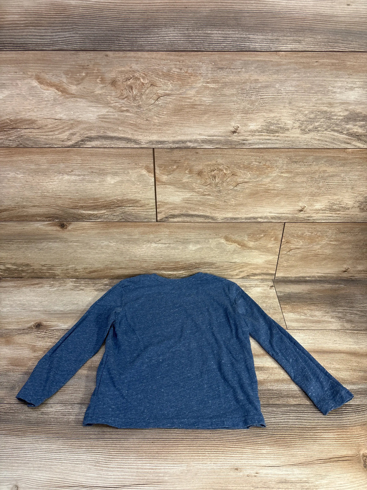 Front view of Jumping Beans blue long sleeve shirt in size 5T showcasing its relaxed fit with a wood plank background