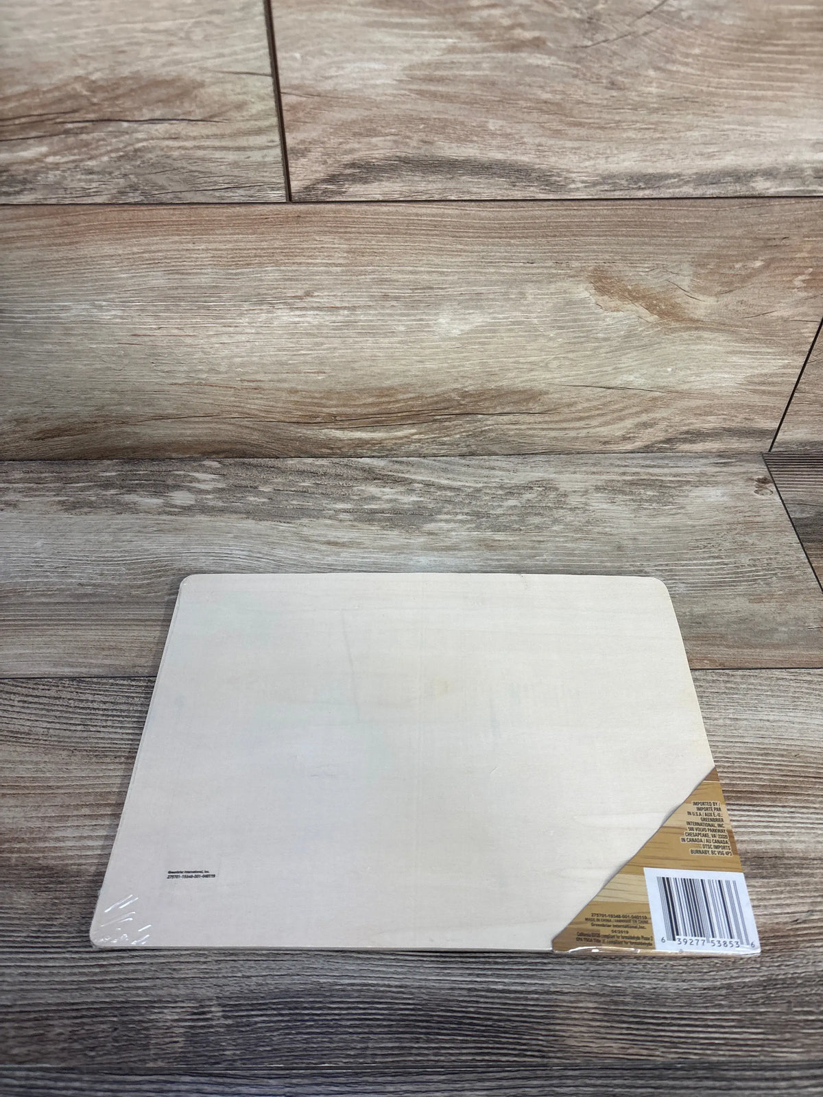 Top view of wooden farm animal puzzle back showing plain birch board and corner barcode sticker on wood backdrop