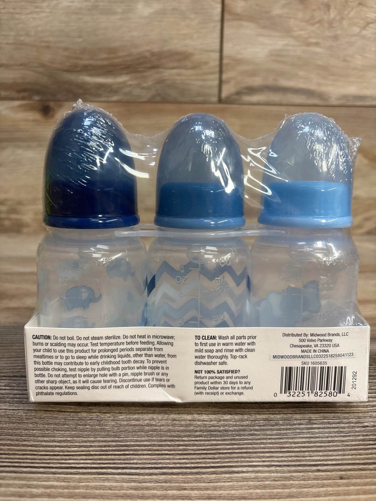 Pack of three baby bottles with blue caps, elephant and chevron designs, packaged in plastic