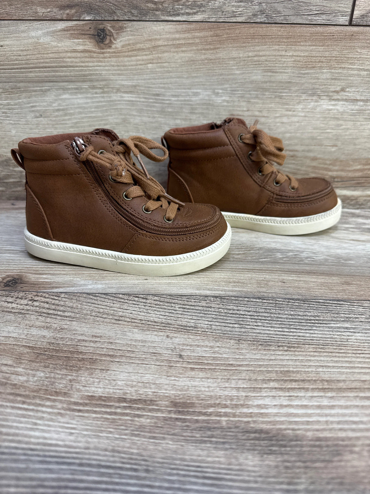 Side view of Billy Footwear brown toddler high-top sneakers size 9C with side zipper and rubber sole on wood background