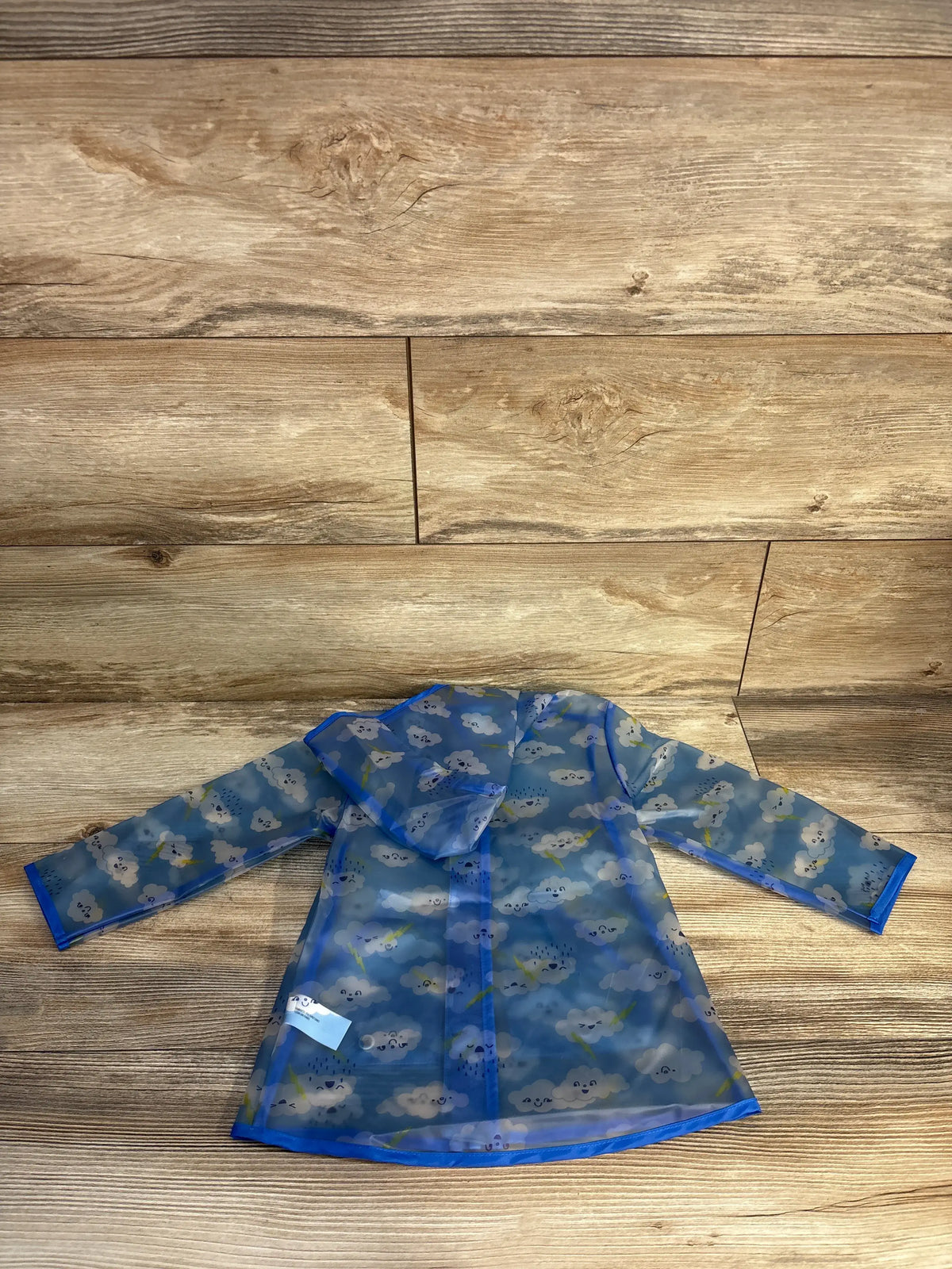 Cat & Jack cloud printed clear blue rain jacket for toddlers, size 18m, on wood background