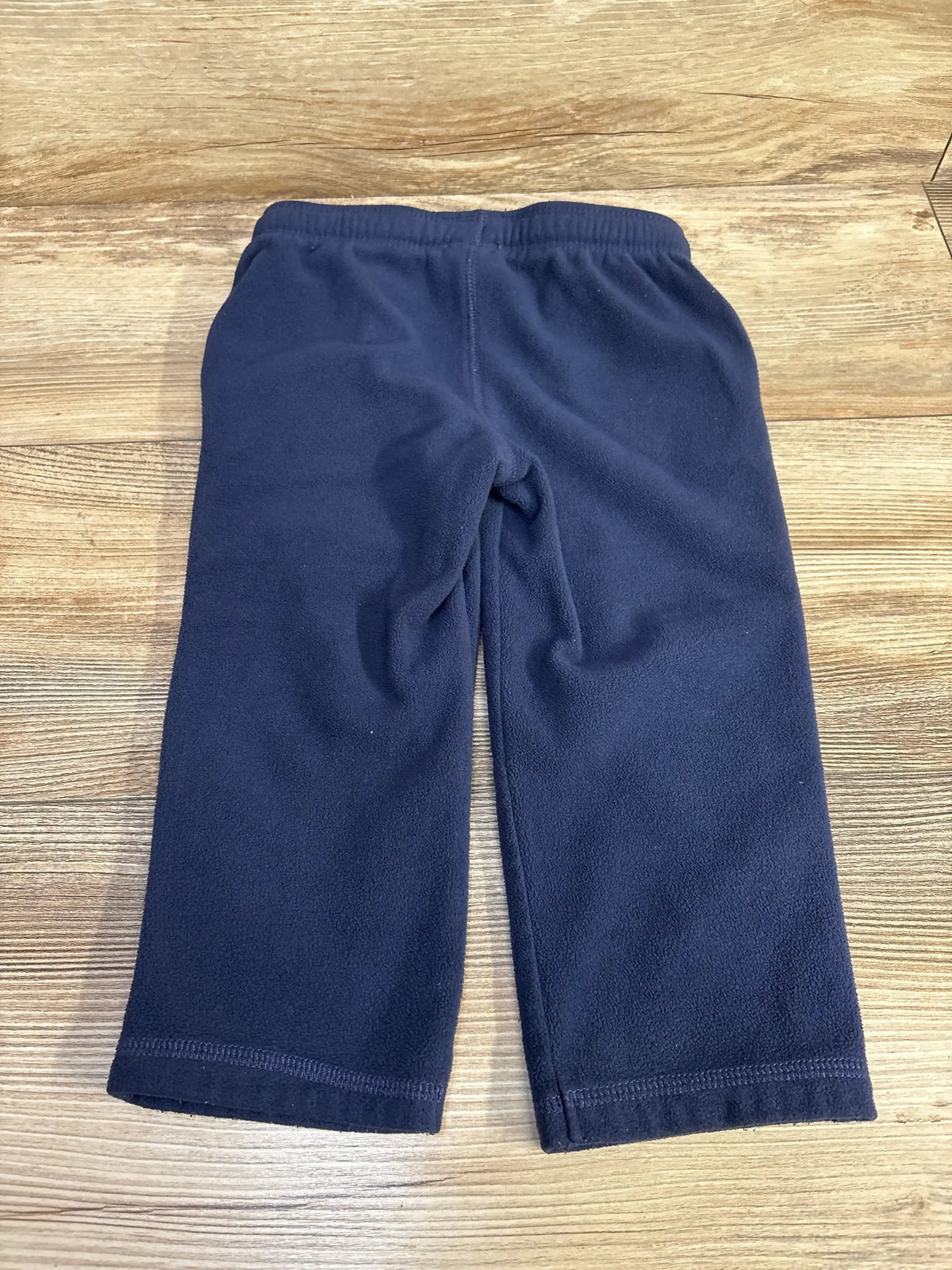 Navy fleece toddler pants with elastic waistband on wooden floor