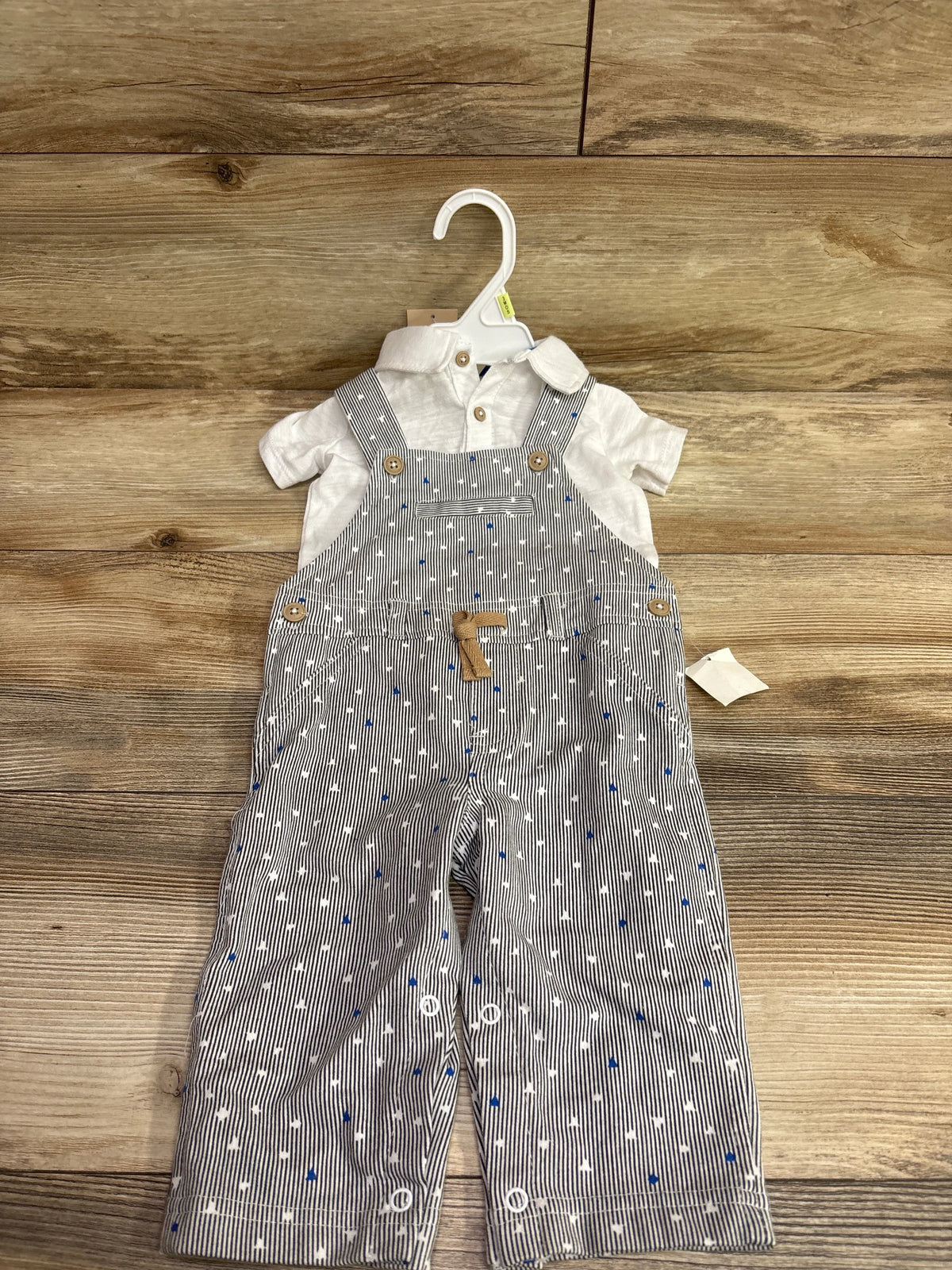 Front view of First Impressions polo shirt and overalls set, size 6 to 9 months, with striped overalls and white polo shirt