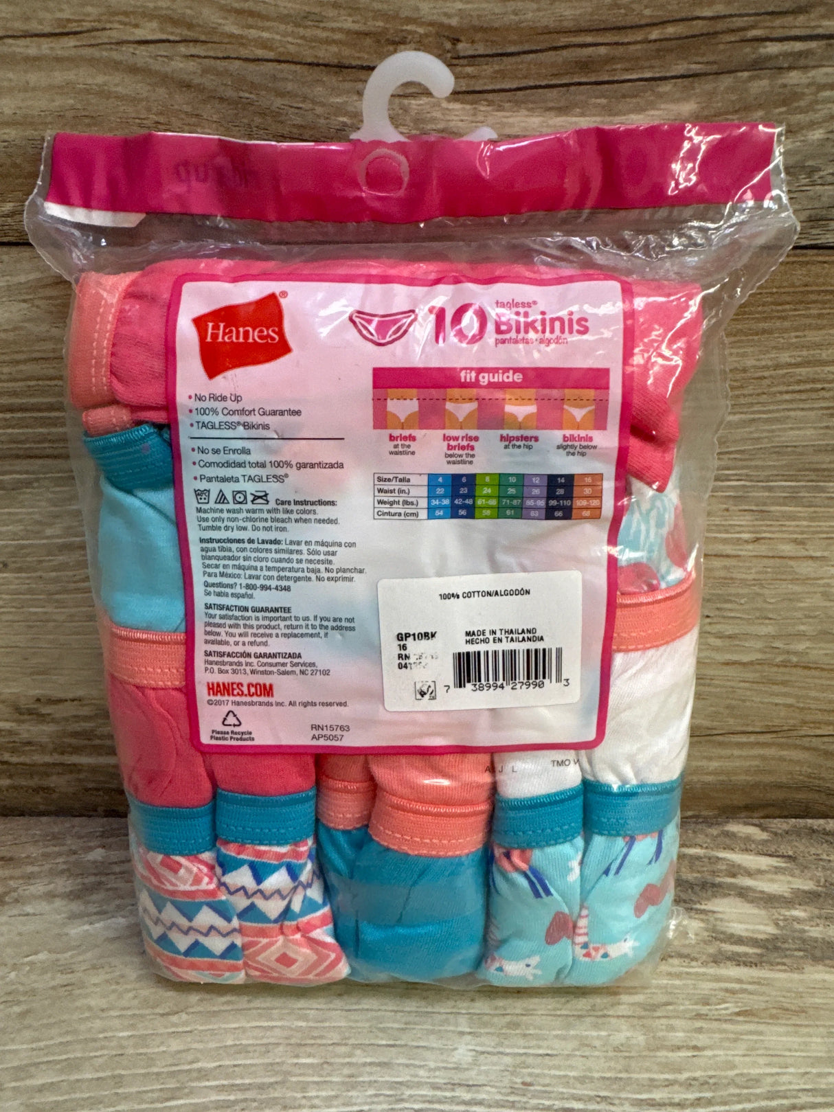 Front of Hanes girls 10 pack tagless bikini underwear showing assorted pink and turquoise in clear packaging on wood