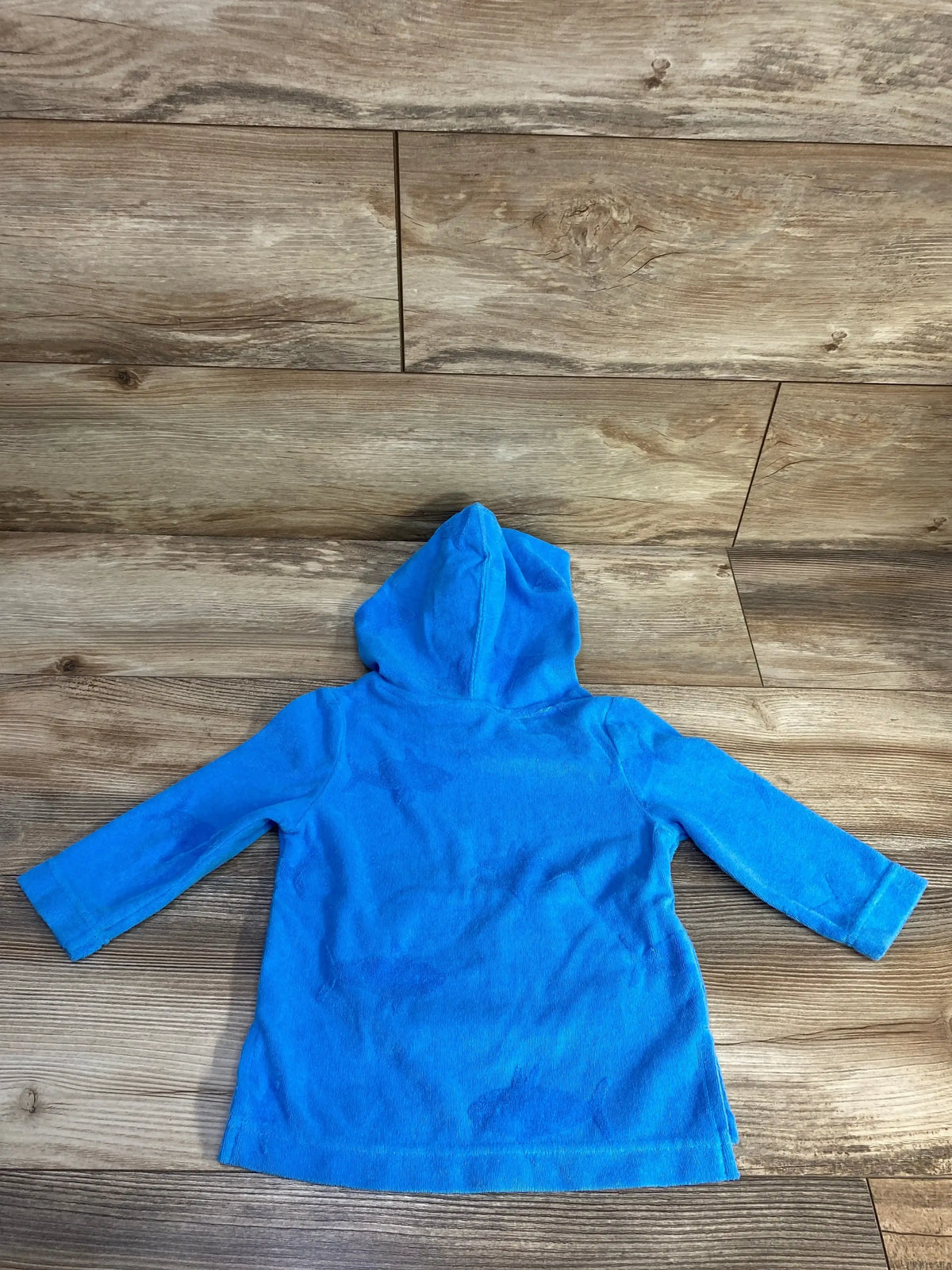 Back view of Cat and Jack shark terry toddler swim cover-up in blue showing hood and long sleeves on wood floor
