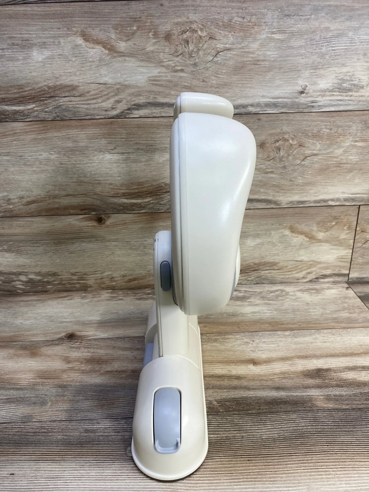 Side view of IvyWind wall mounted baby shower stand showcasing folding hinge and mounting base with wood plank background