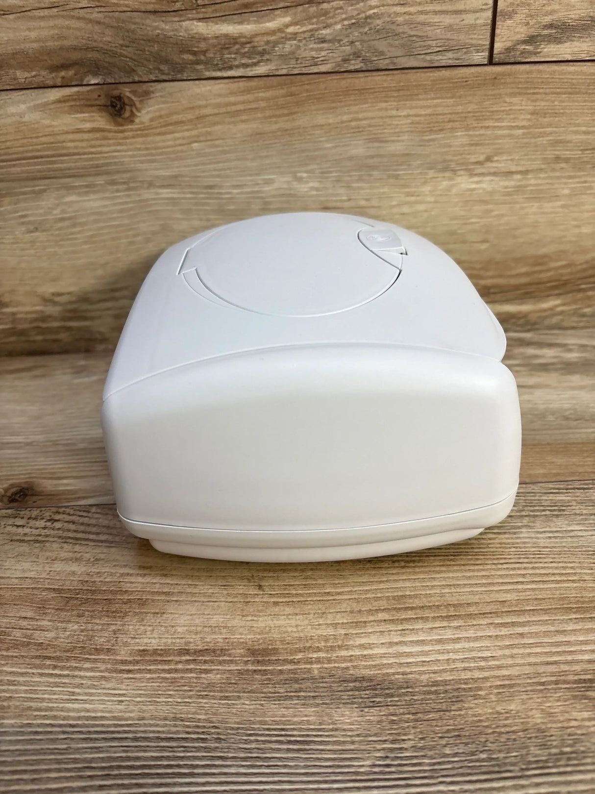 Front view of Prince Lionheart Ultimate Wipes Warmer showing white rounded front and top circular lid on wood background