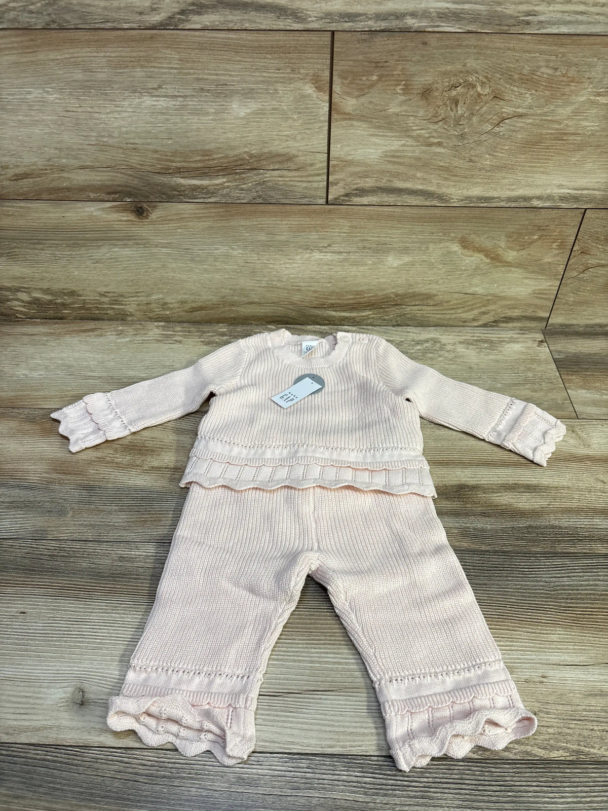New pink 2-piece crochet baby outfit set featuring a long sleeve top and ruffled pants