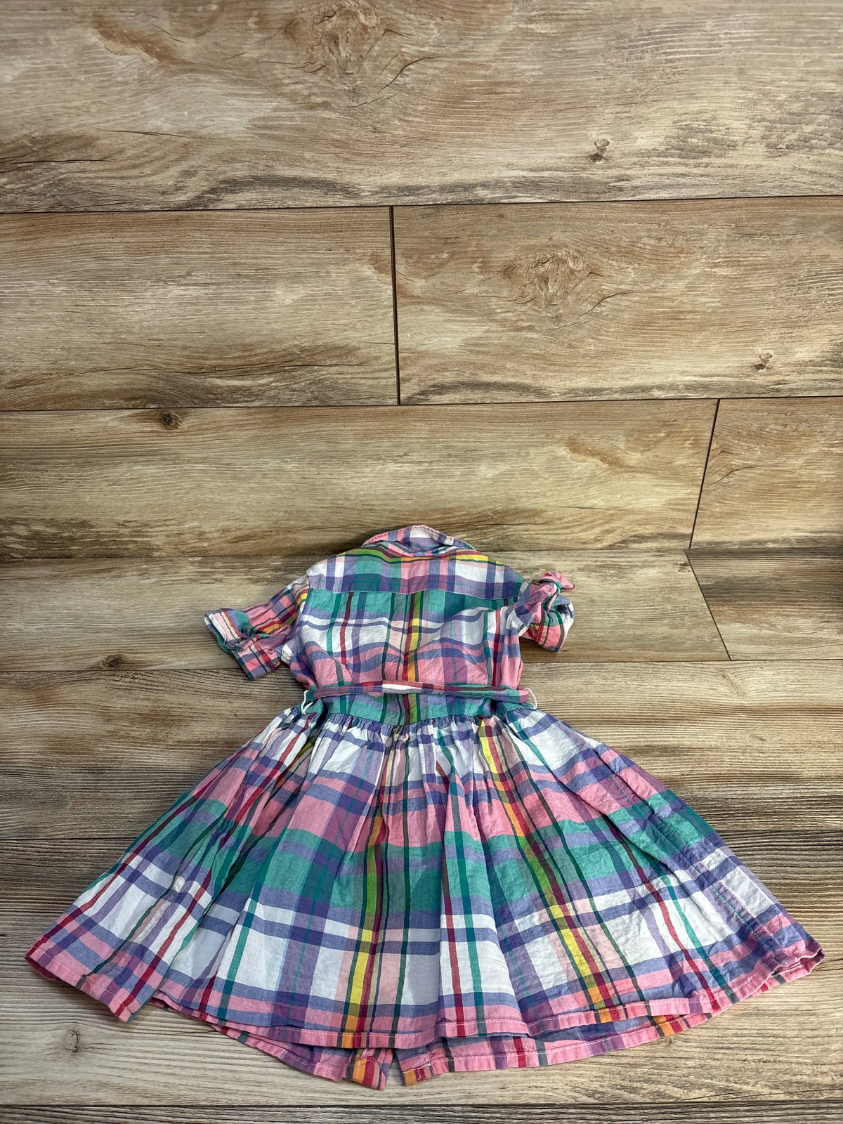 Top view of Polo Ralph Lauren multicolor plaid cotton madras shirtdress with Peter Pan collar and fit-and-flare skirt on wood