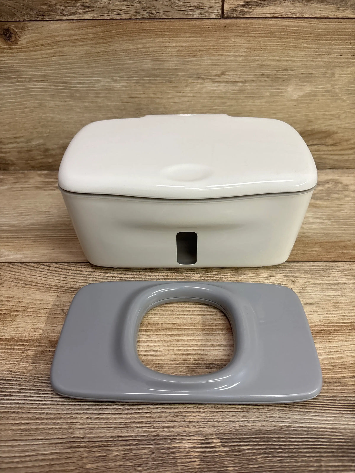 Front view of OXO Tot Perfect Pull Wipes Dispenser with white lid and separate gray insert on a wood surface