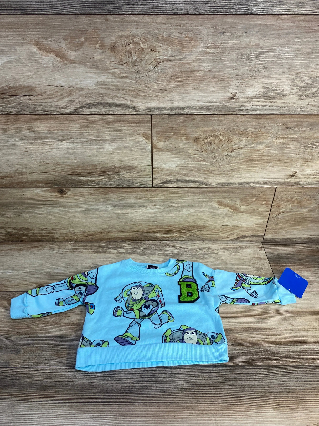 Light blue kids long sleeve shirt with Buzz Lightyear cartoon print and letter B patch