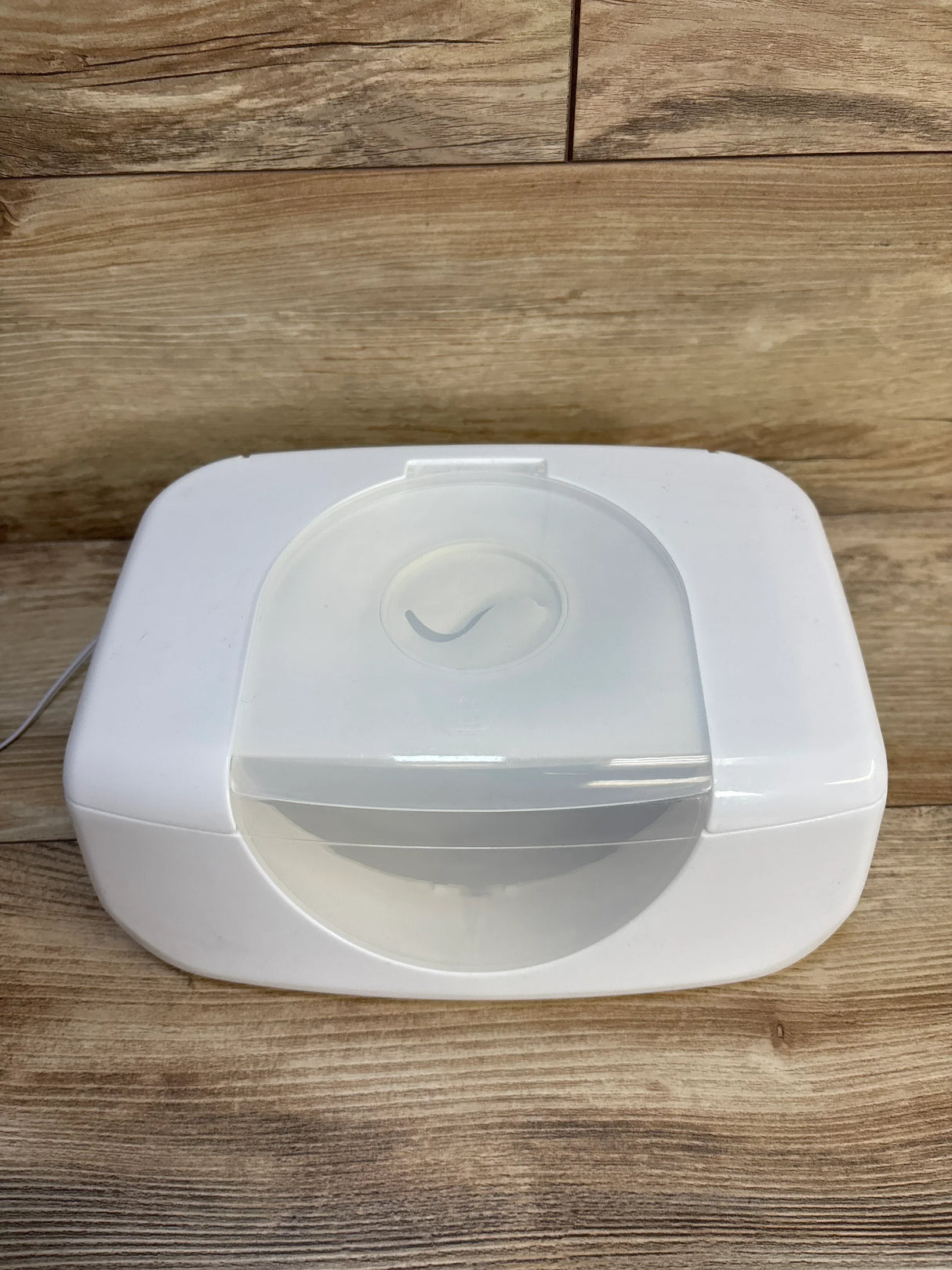 White baby wipe warmer with clear lid on wood surface, ideal for nursery essentials and baby gear