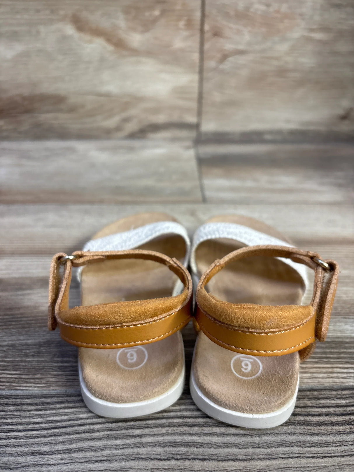 Rear view of Cat and Jack tan toddler sandals showing adjustable ankle straps and suede footbed with size 9 marking on wooden floor