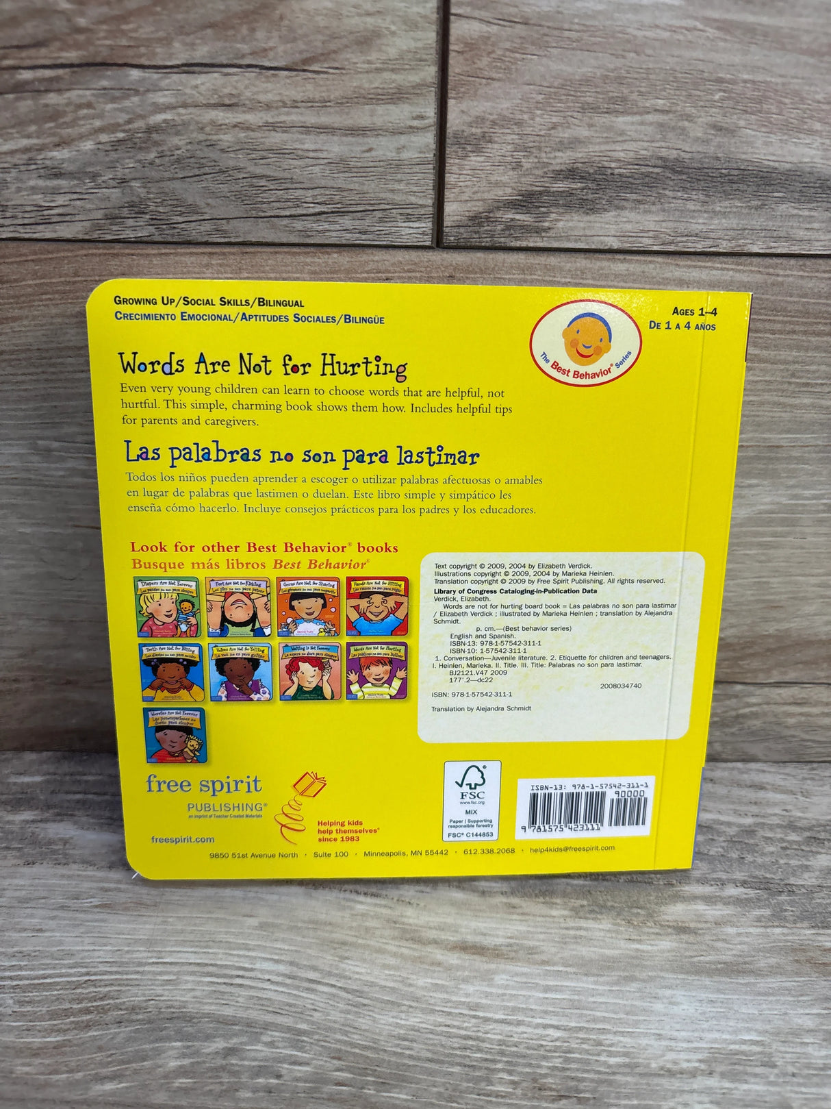Back cover of 'Words Are Not for Hurting' bilingual children's book on wood background