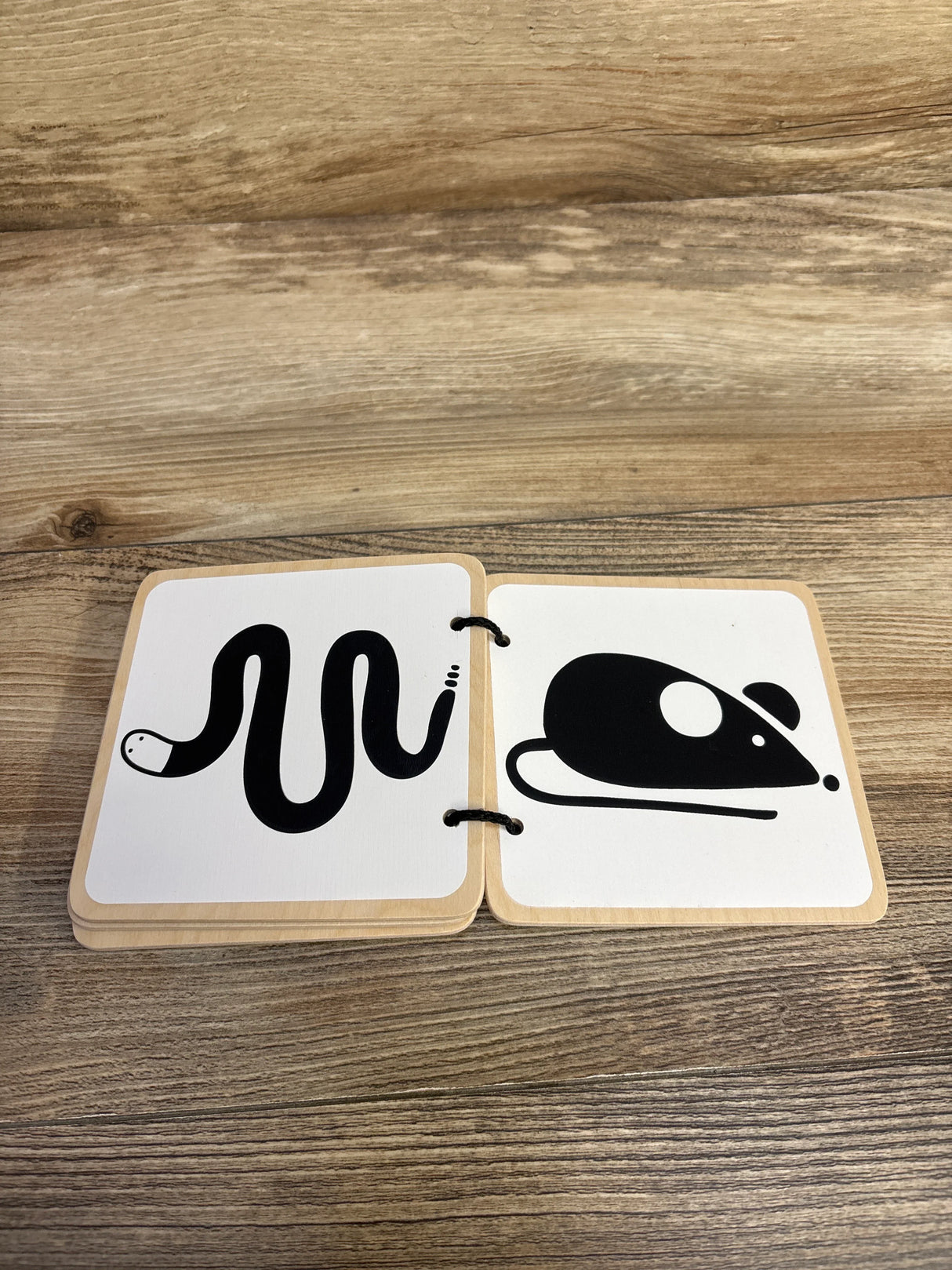 Wooden flashcards showing black and white snake and mouse illustrations on wood surface