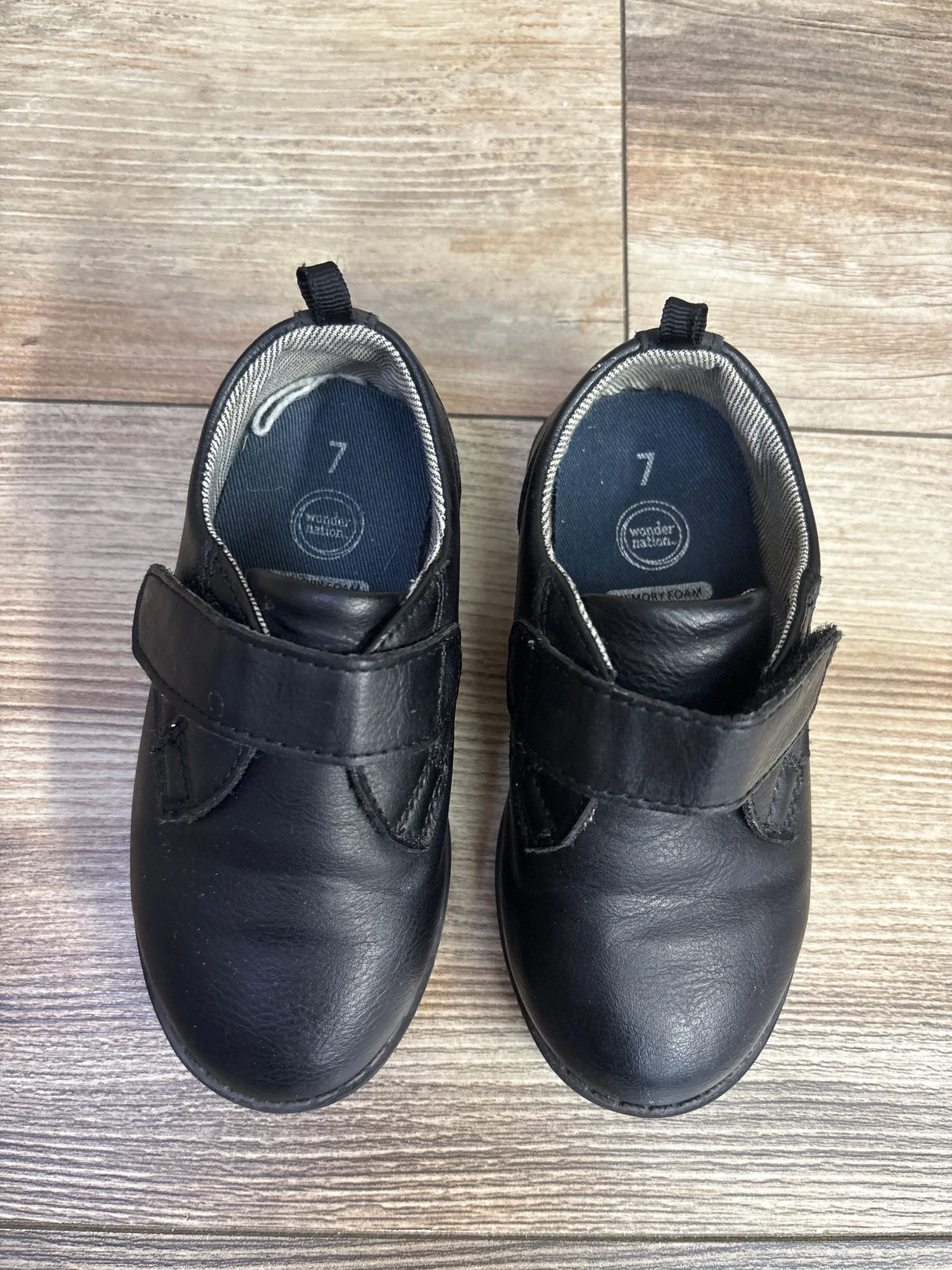 Top view of Wonder Nation Oxford dress shoes size 7C showcasing Velcro strap closure and rounded toe on wood floor