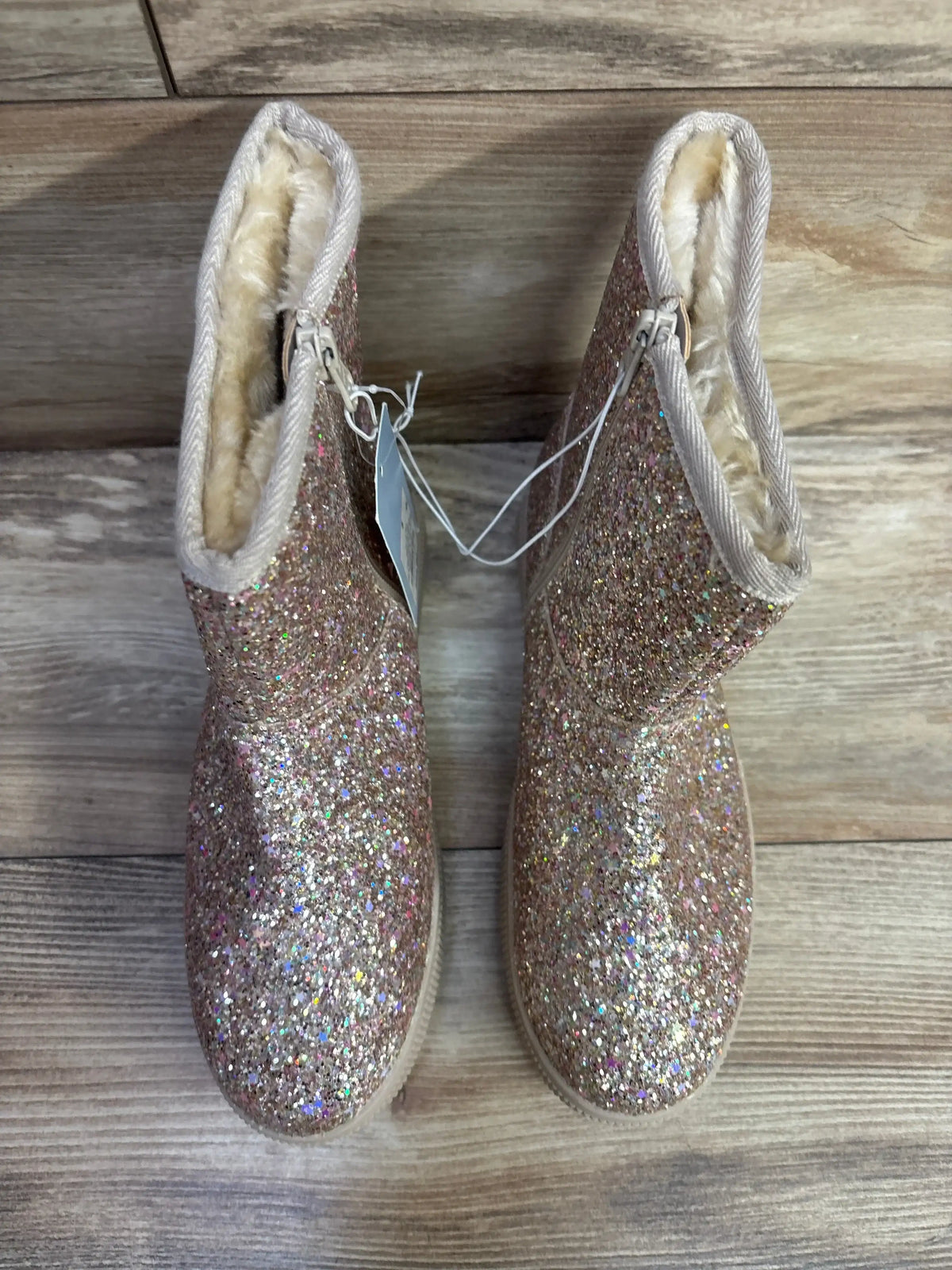 Top view of Cat & Jack Holland shearling-style toddler boots showcasing glittery gold exterior and faux-shearling lining on wooden floor