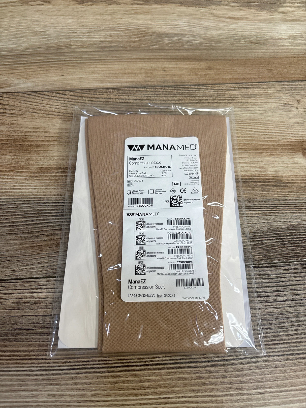 ManaEZ compression sock large size in beige packaging on wooden surface