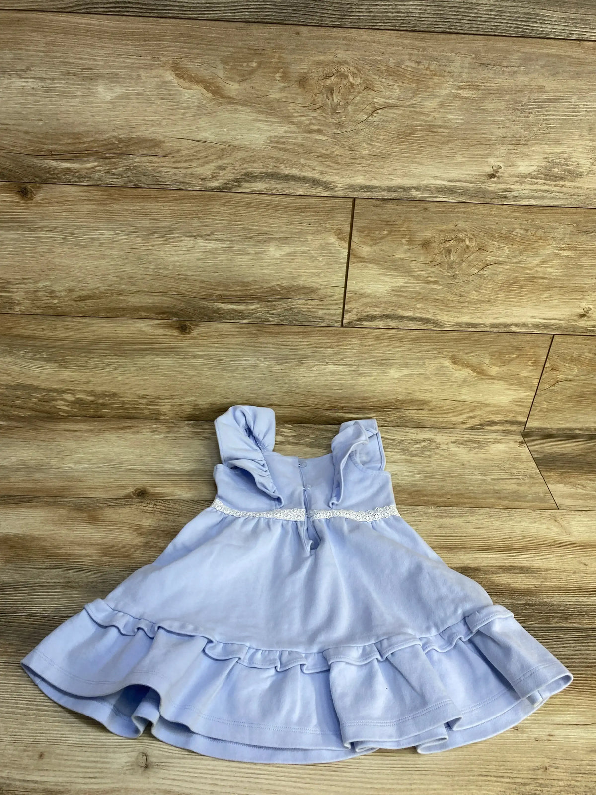 Flat lay of Janie and Jack Ruffle Ponte Dress in blue sz 3T showcasing ruffle straps and tiered hem on wood plank floor