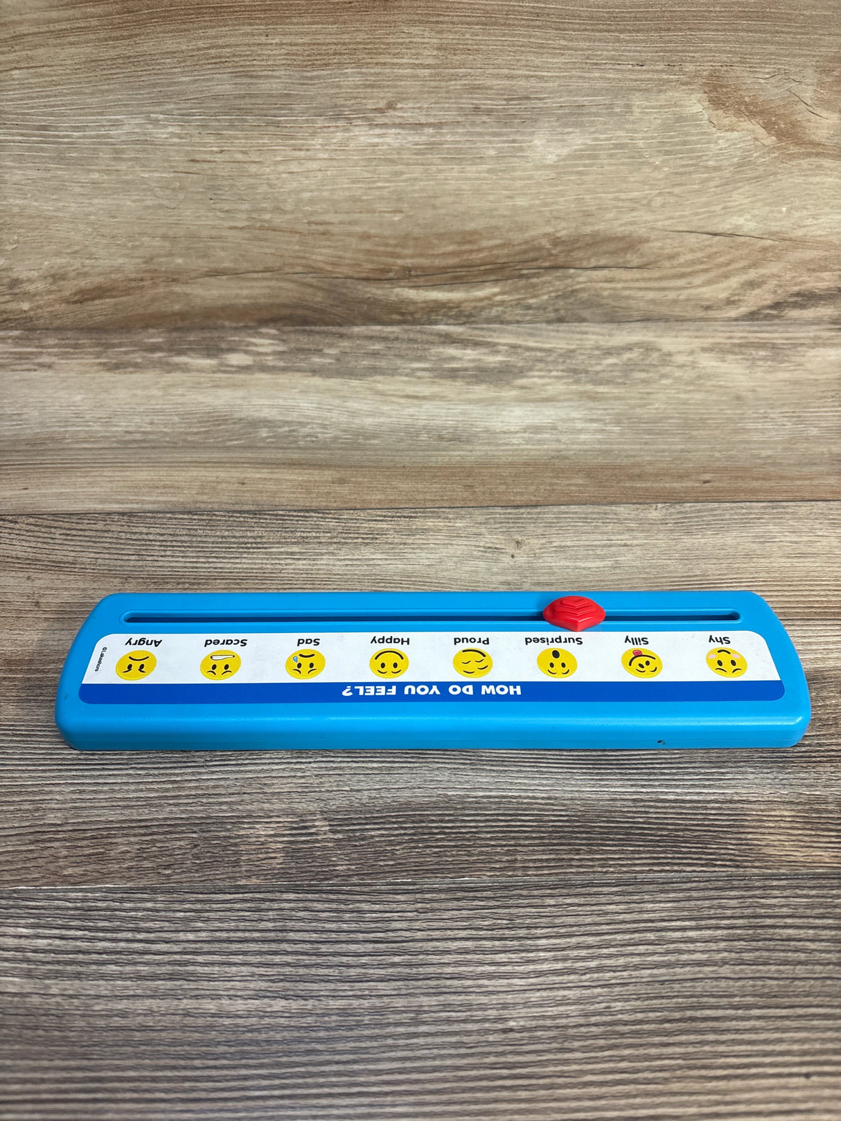 Kids emotion slider toy with emoji faces and feelings chart on wood background