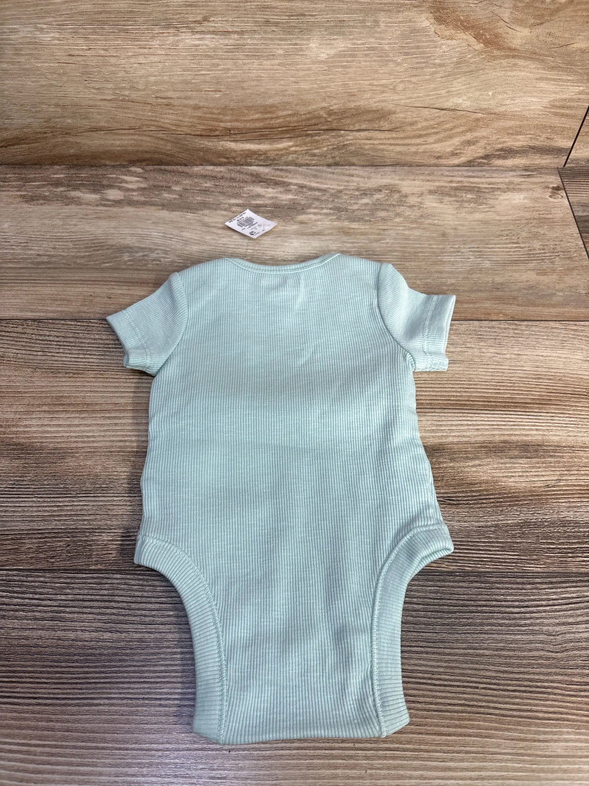 New Baby Gap ribbed bodysuit in mint green, size 0-3m, laid flat on a wooden surface.