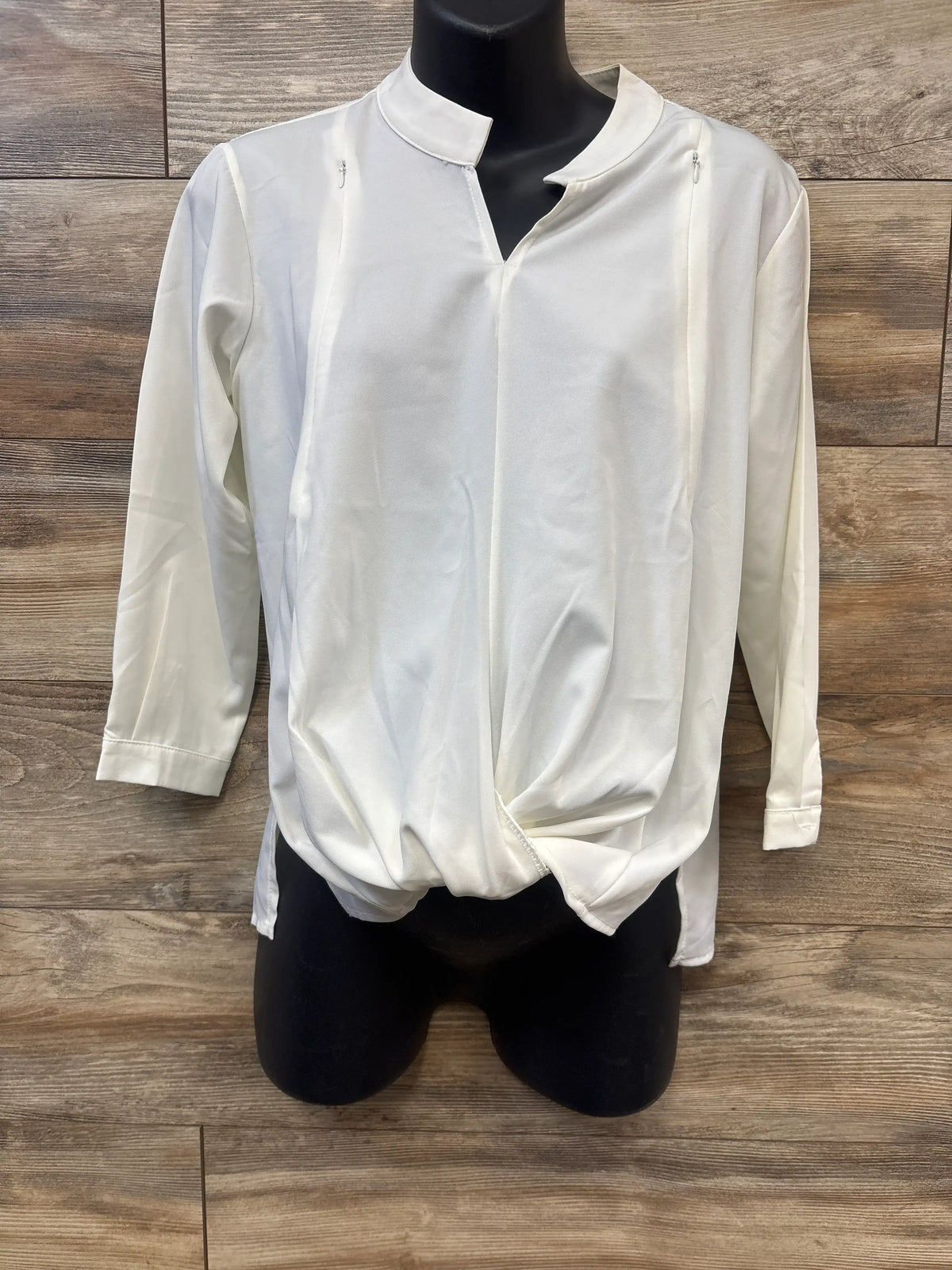 Front view of Classic Designs white long sleeve nursing blouse showcasing zippered nursing openings with wood plank background