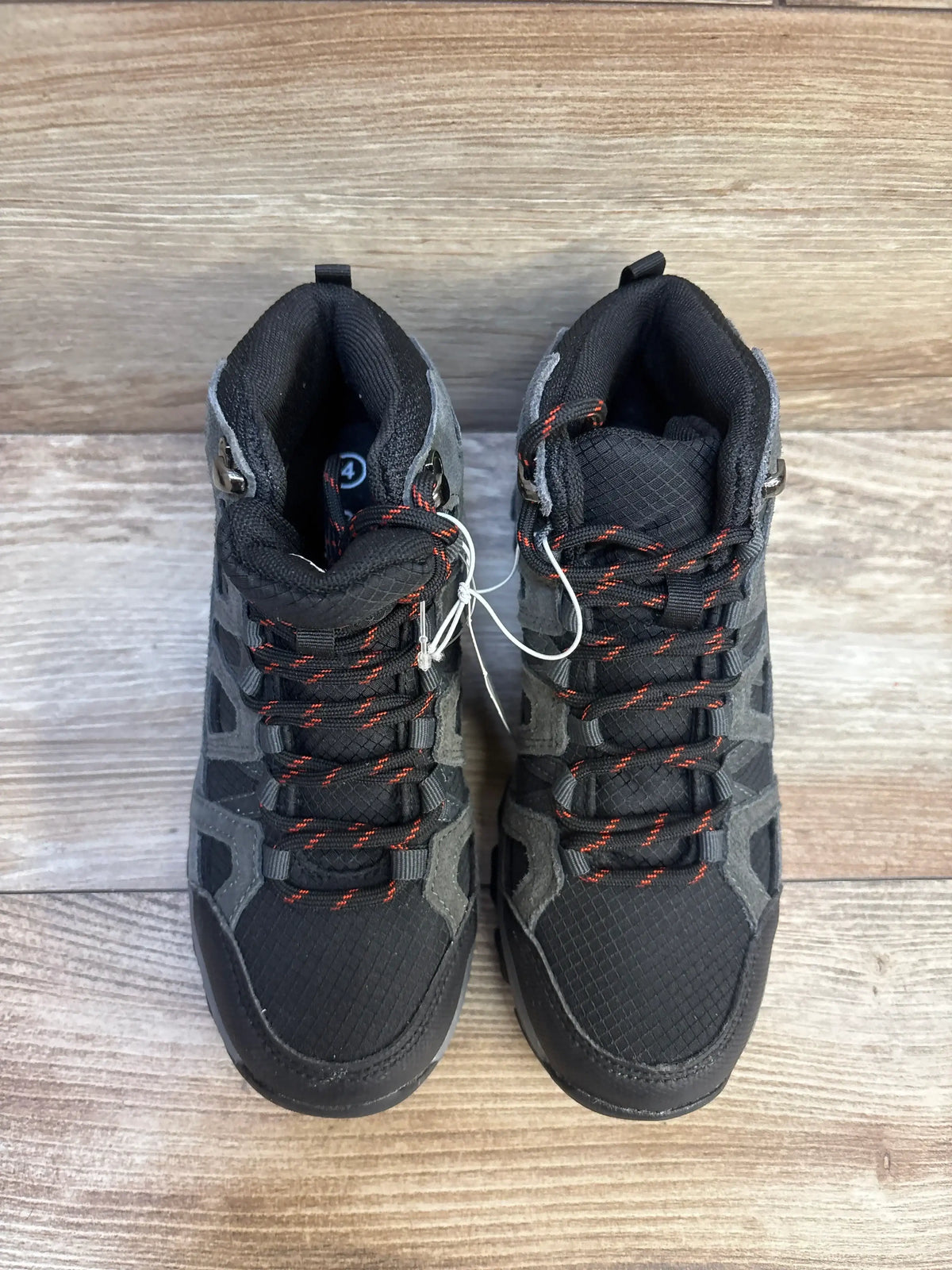 Top view of Cat and Jack Patsy kids’ hiking boots size 4Y showing black and gray upper with red laces on wood floor