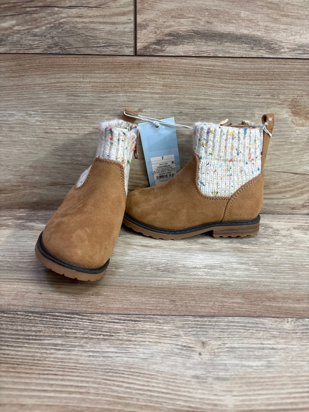 Tan toddler boots with knit cuffs and rubber soles on wood background, size 7.