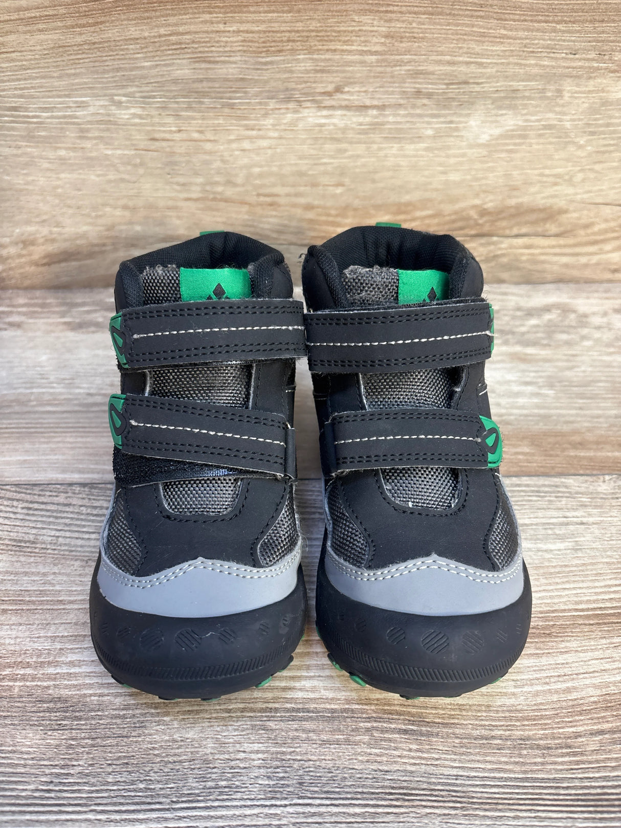Black and gray toddler boots with green accents on wood background, Velcro closure