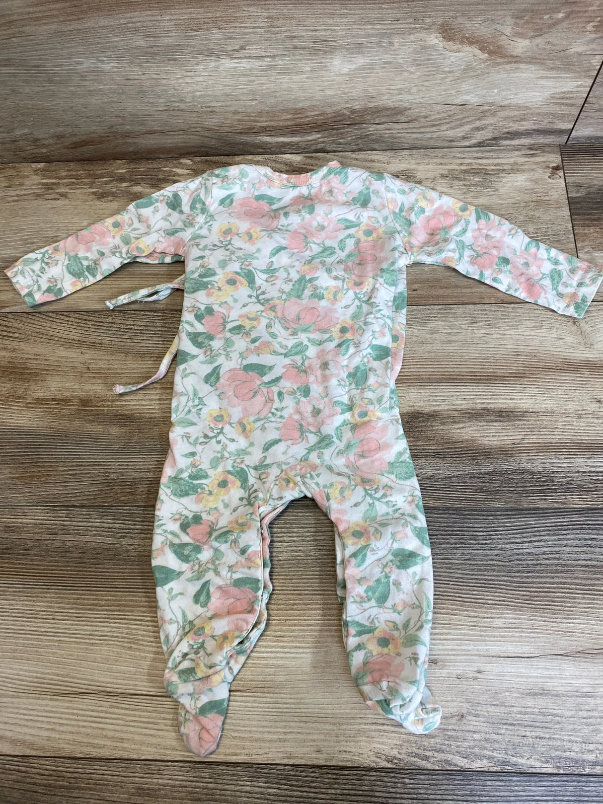 Flat-lay back view of Rachel Zoe coverall size 6-9M showcasing floral print, long sleeves and attached feet with wood background