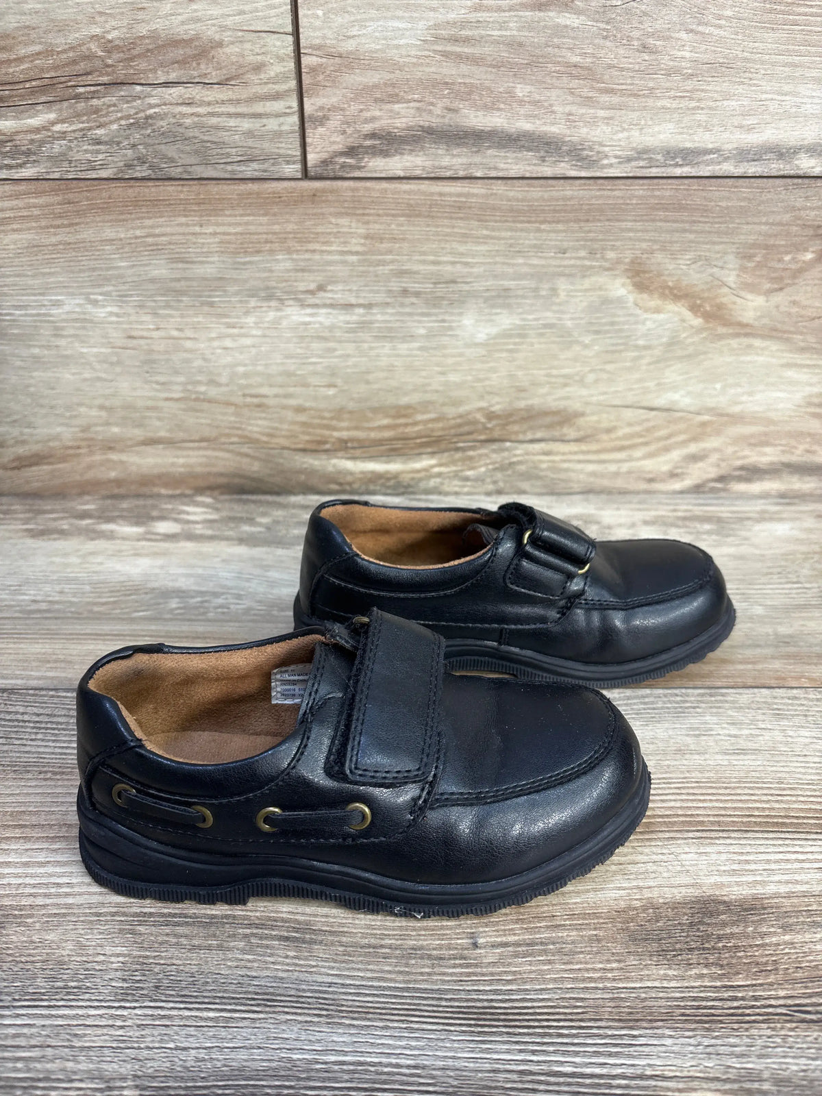 Children's Place black faux leather dress shoes for kids size 11c on a wood background