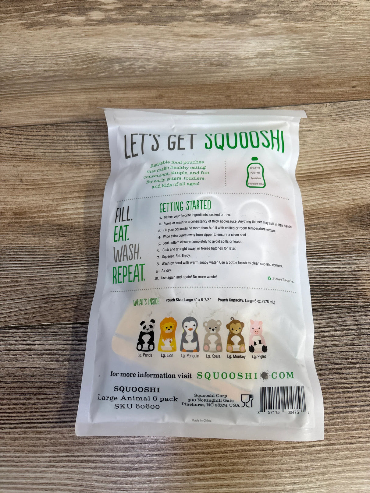 Squooshi reusable food pouch packaging on wood, featuring animal designs and usage instructions.
